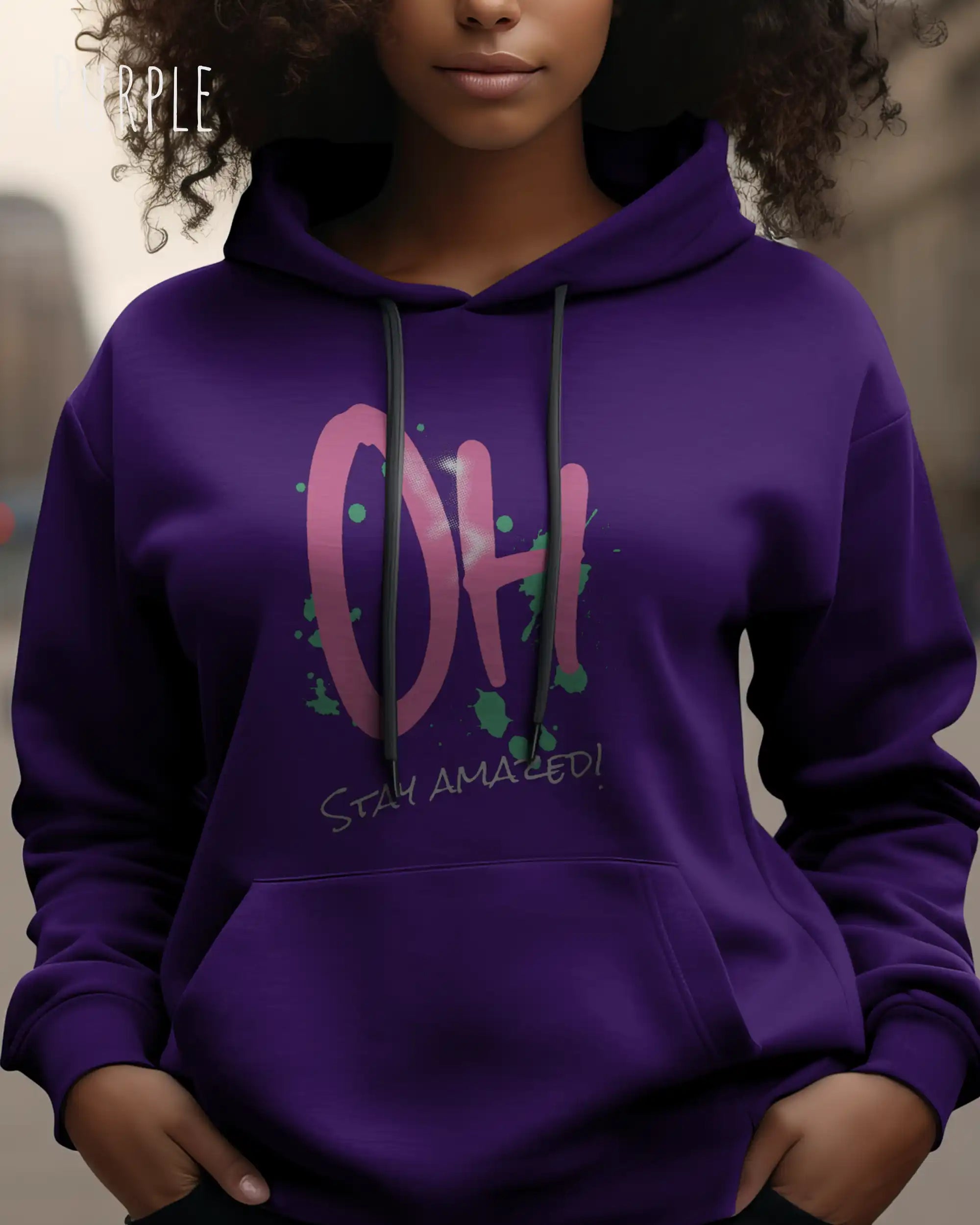 Frau trägt hoodie im feminine fit aus weicher baumwollmischung in farbe purple mit stay amazed motiv auf der Brust