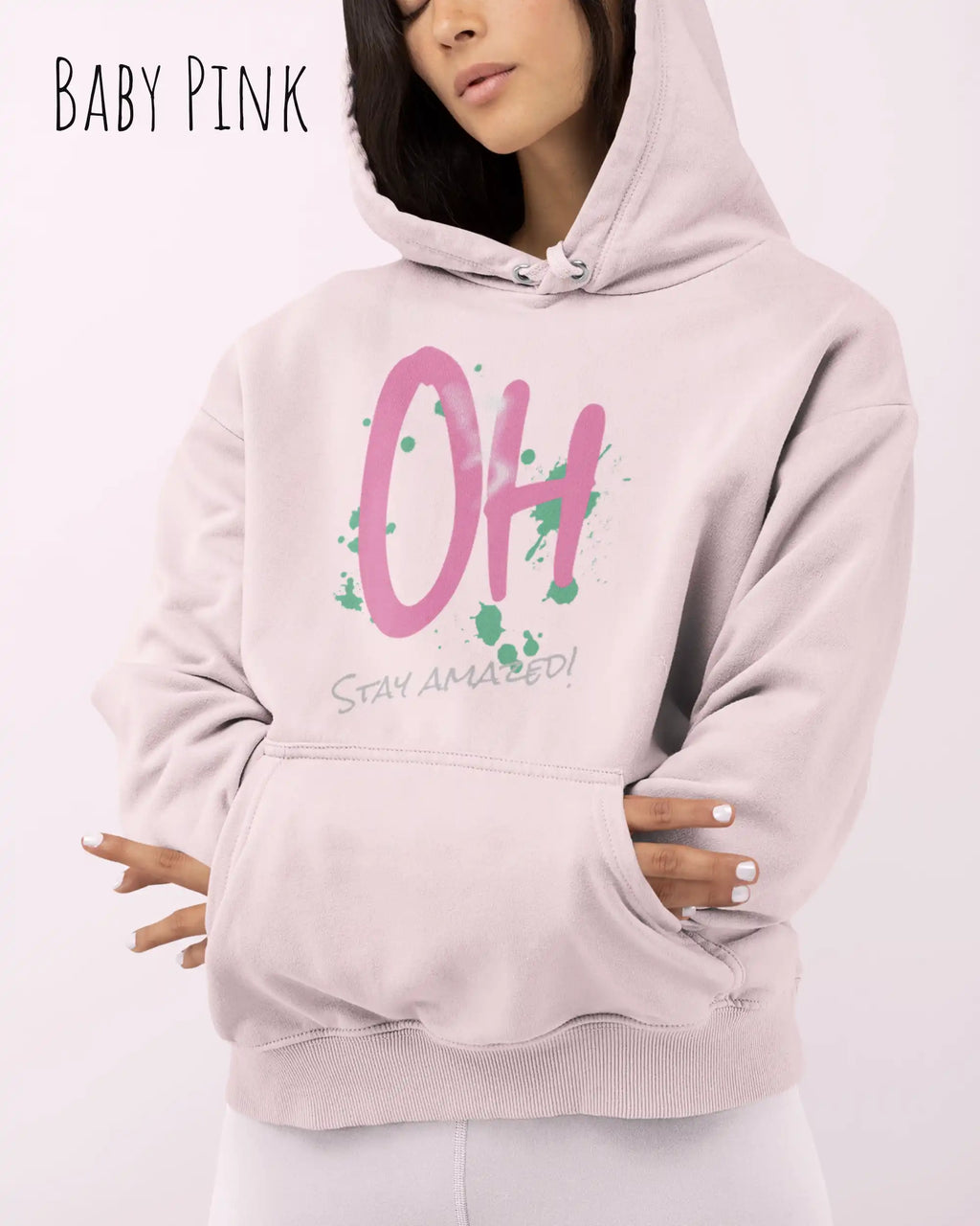 Frau trägt hoodie im feminine fit aus weicher baumwollmischung in farbe baby pink mit stay amazed motiv auf der Brust