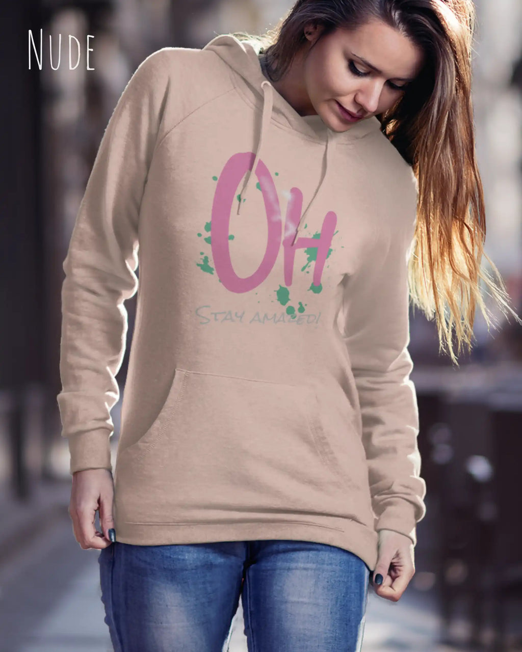 Frau trägt hoodie im feminine fit aus weicher baumwollmischung in farbe nude mit stay amazed motiv auf der Brust