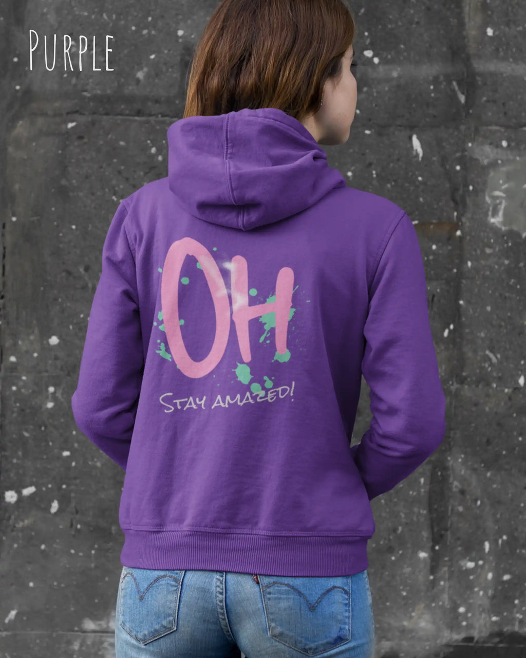 Frau trägt hoodie im feminine fit aus weicher baumwollmischung in farbe purple mit stay amazed motiv hinten