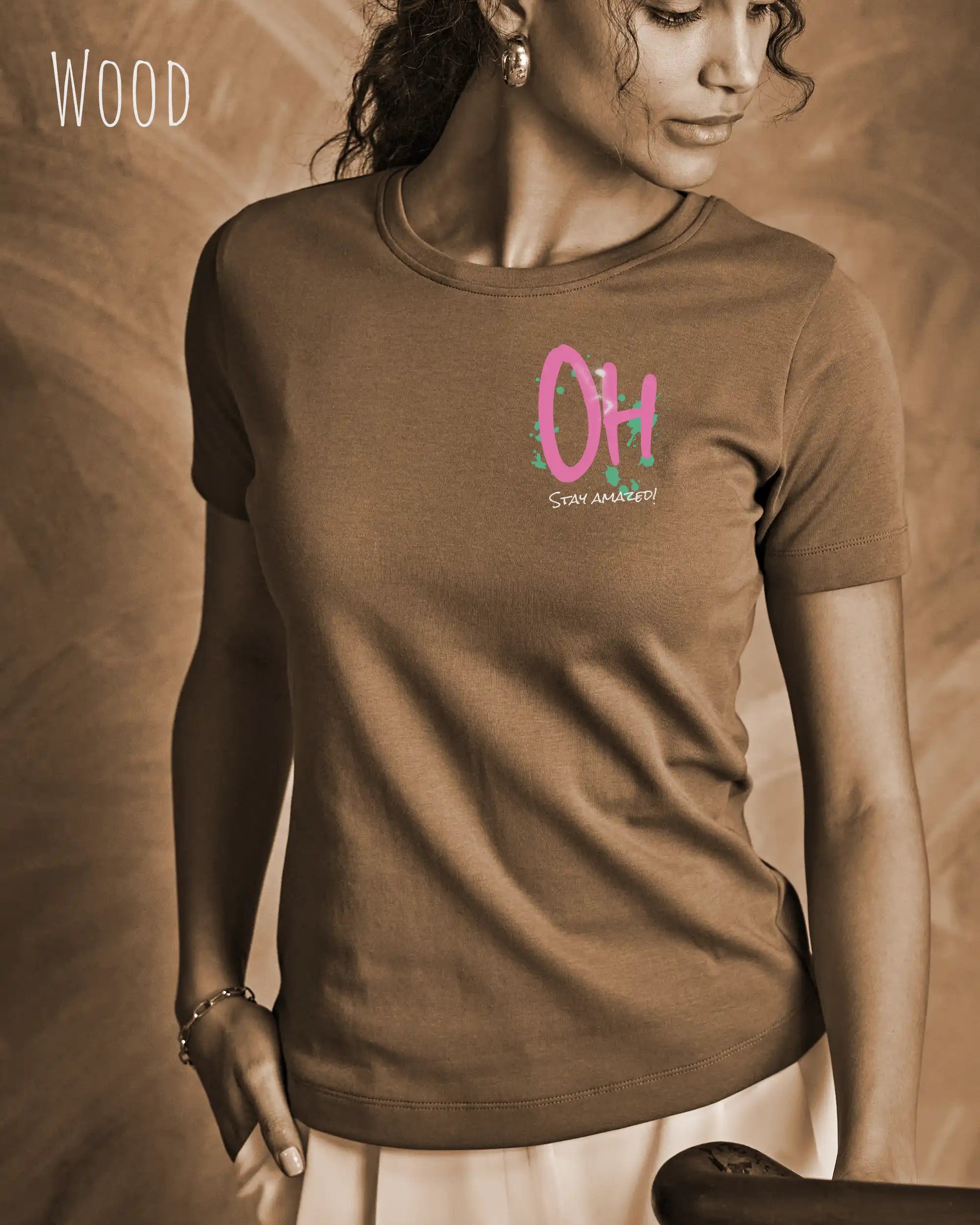 Das Bild zeigt eine frau, die ein feminines Grafik t-shirt in der farbe wood und mit dem design  stay amazed trägt.