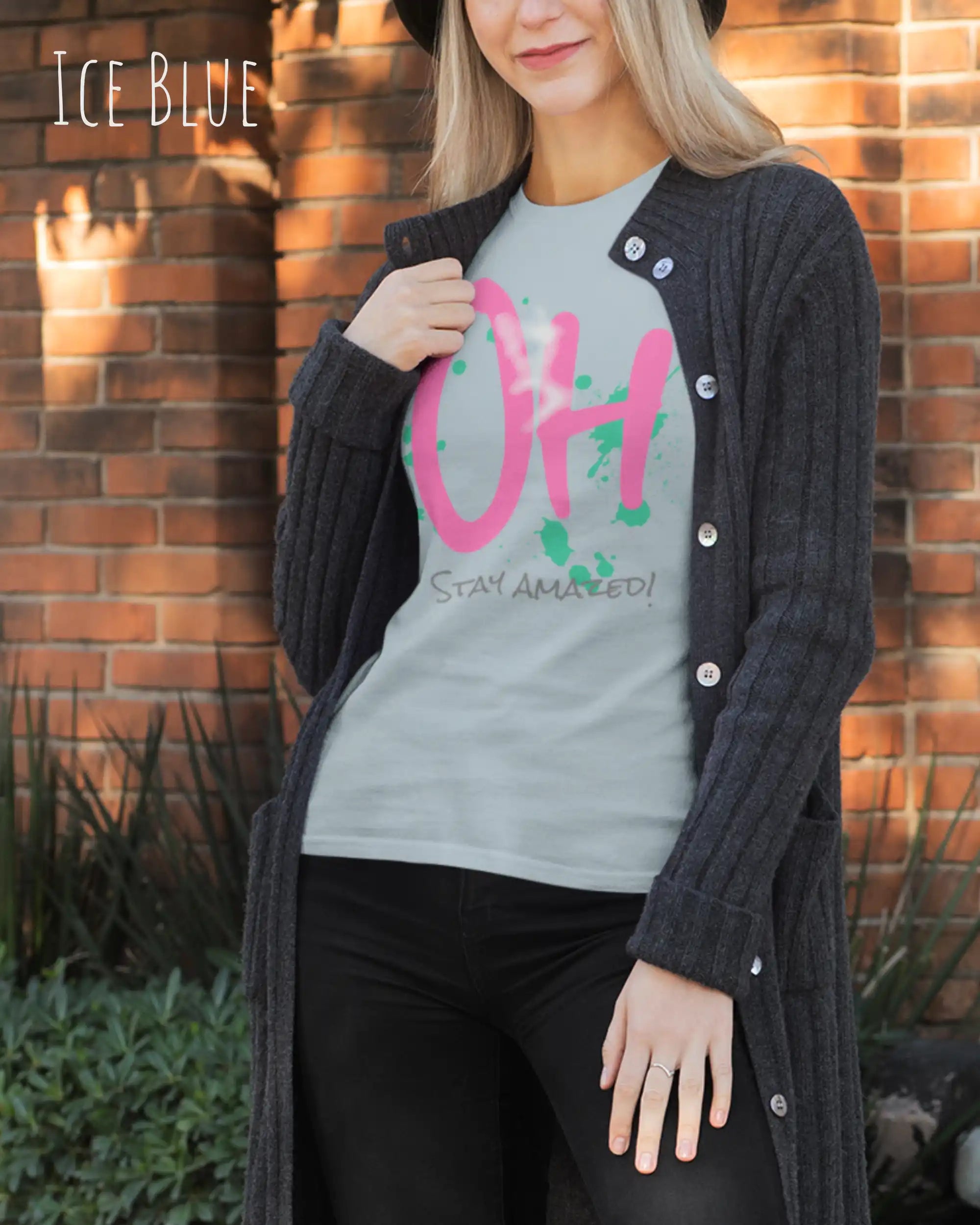 Das Bild zeigt eine frau, die ein feminines Grafik t-shirt in der farbe iceblue und mit dem frontprintdesign  stay amazed trägt.