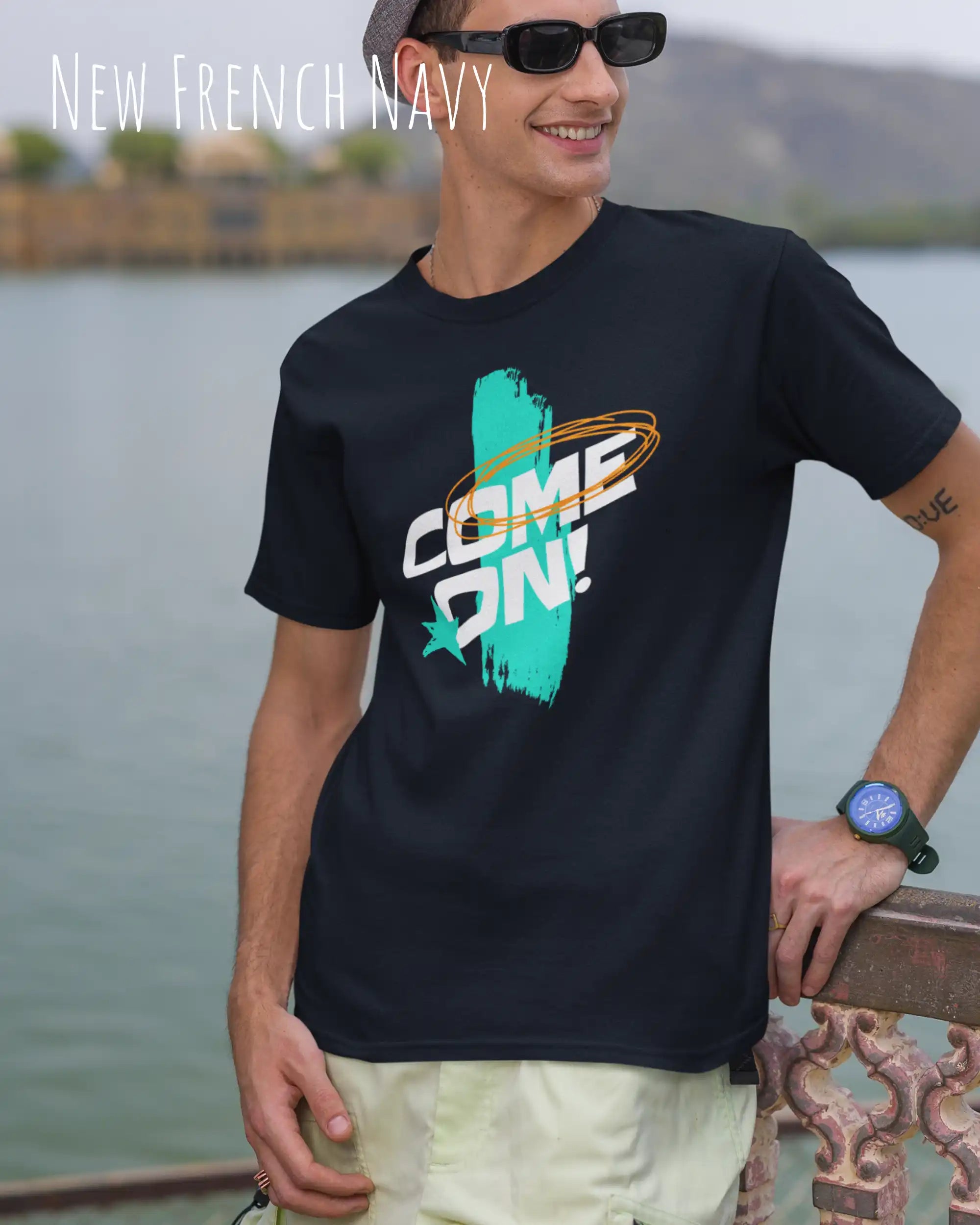 Ein Mann  trägt ein Unisex-Design-T-Shirt in der Farbe new french navy mit dem motiv come on vorne mittig.