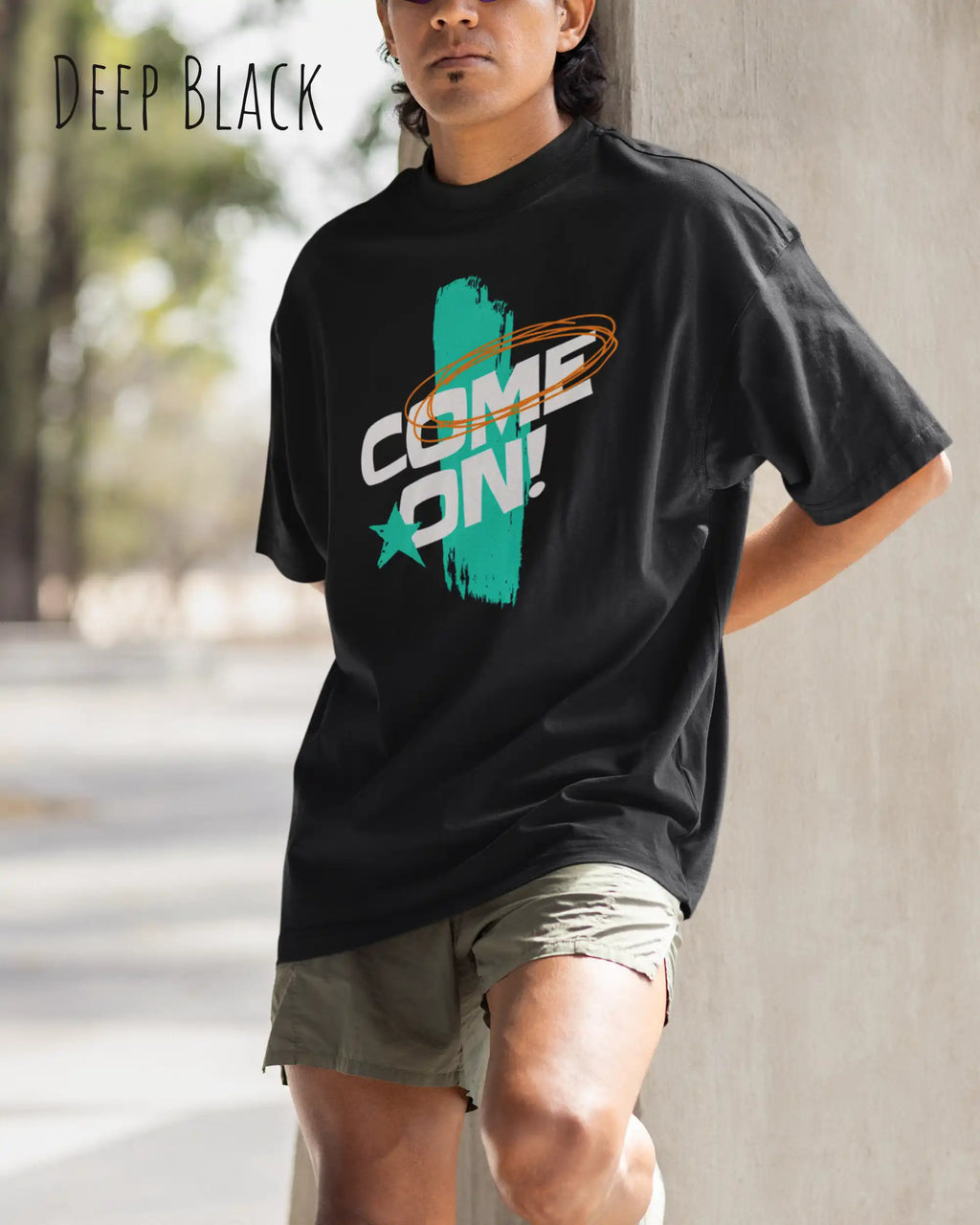 mann trägt  ein oversized heavyweight grafik-t-shirt in der farbe deep black mit dem design come on! vorne