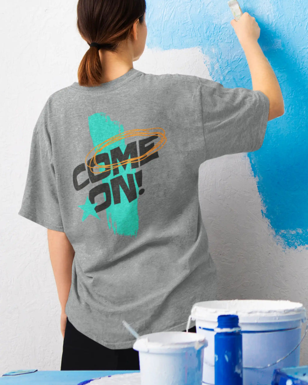 frau trägt  ein oversized heavyweight grafik-t-shirt in der farbe heather grey mit dem backprint design come on!