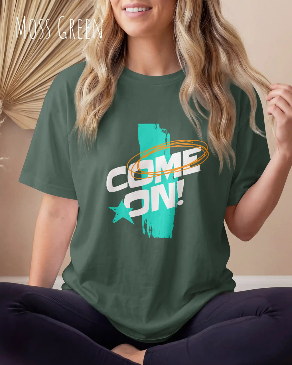 frau trägt  ein oversized heavyweight grafik-t-shirt in der farbe moss green mit dem design come on!