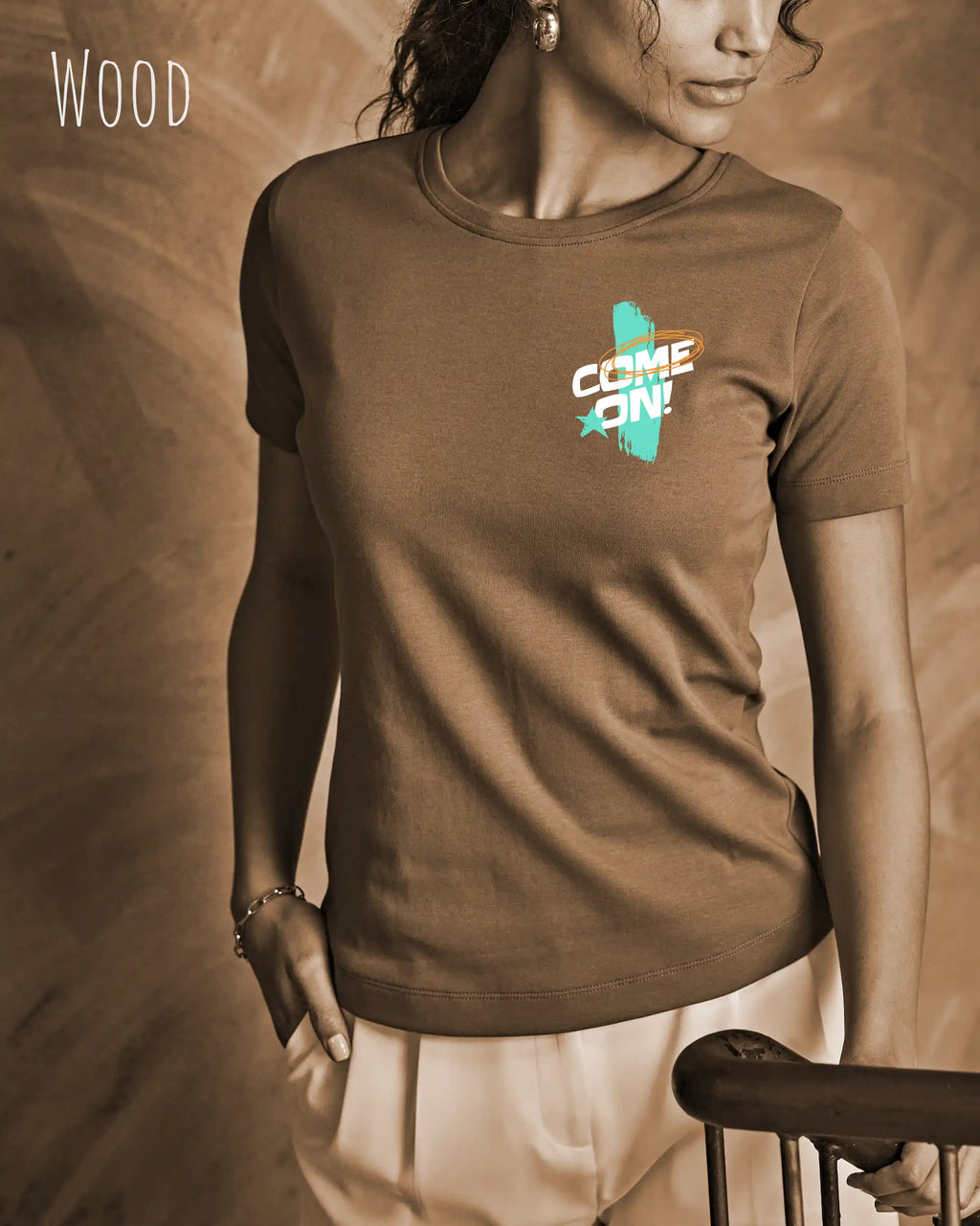 das bild zeigt eine frau, die ein design t-shirt mit femininem schnitt in der farbe wood und mit der dynamischen grafik "come on" oben links trägt