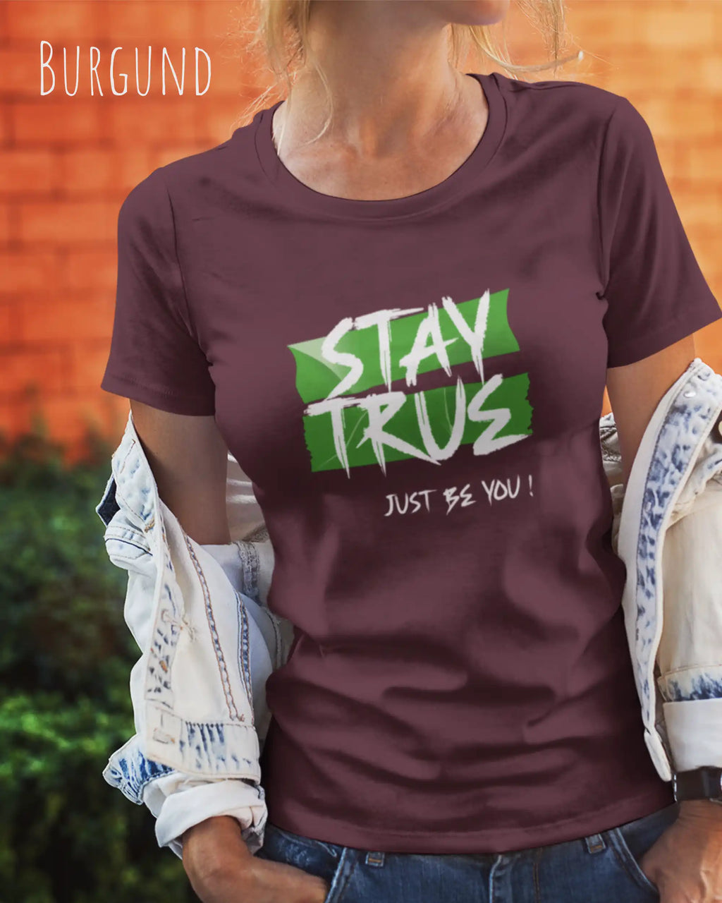 Auf diesem Bild trägt eine frau ein Grafik-t-shirt in der Barbe Burgund und mit dem design stay true.