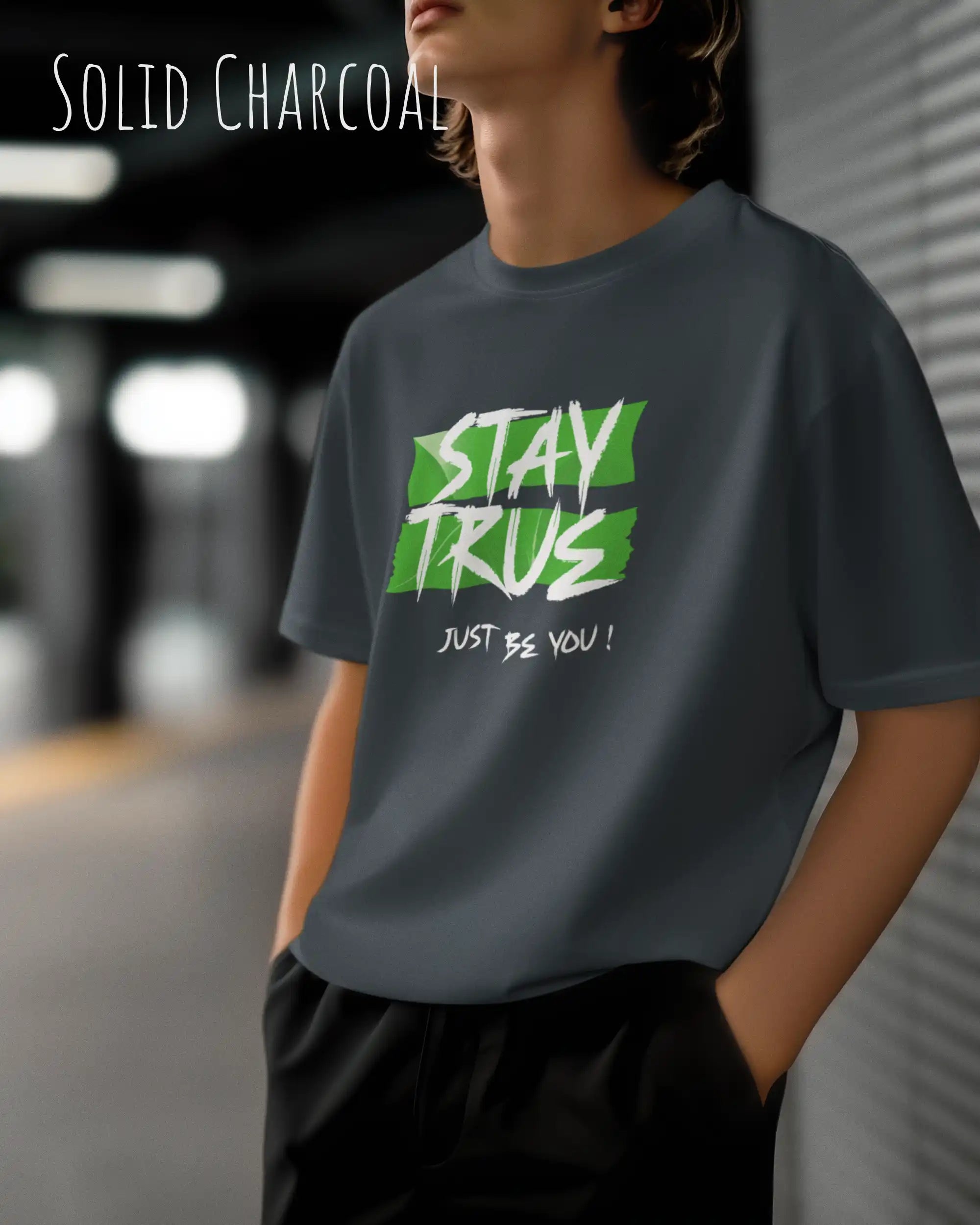 Auf diesem Bild trägt ein mann ein Grafik-t-shirt in der Barbe solid charcoalund mit dem design stay true.