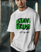 auf diesem bild trägt ein mann ein oversized heavyweight design-t-shirt in der farbe arctic white mit dem statement-motiv stay true.