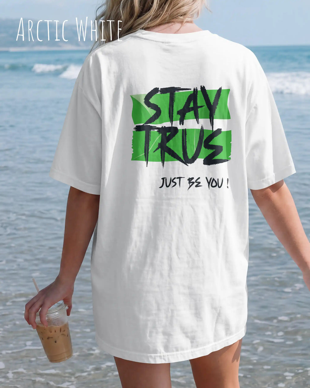 auf diesem bild trägt eine frau ein oversized heavyweight design-t-shirt in der farbe arctic white mit dem statement-motiv stay true auf dem rücken.