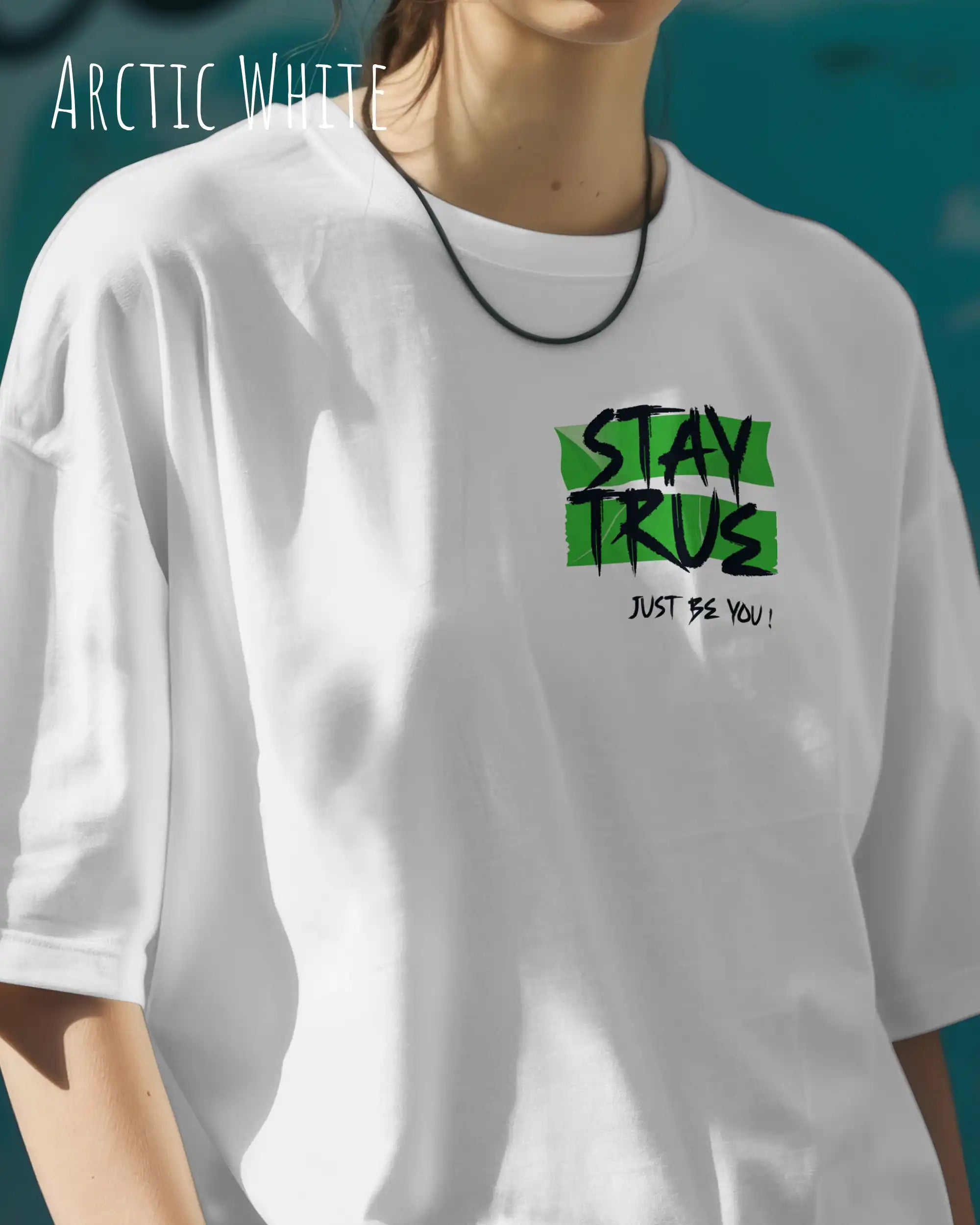 auf diesem bild trägt eine frau ein oversized heavyweight design-t-shirt in der farbe arctic white mit dem statement-motiv stay true oben links