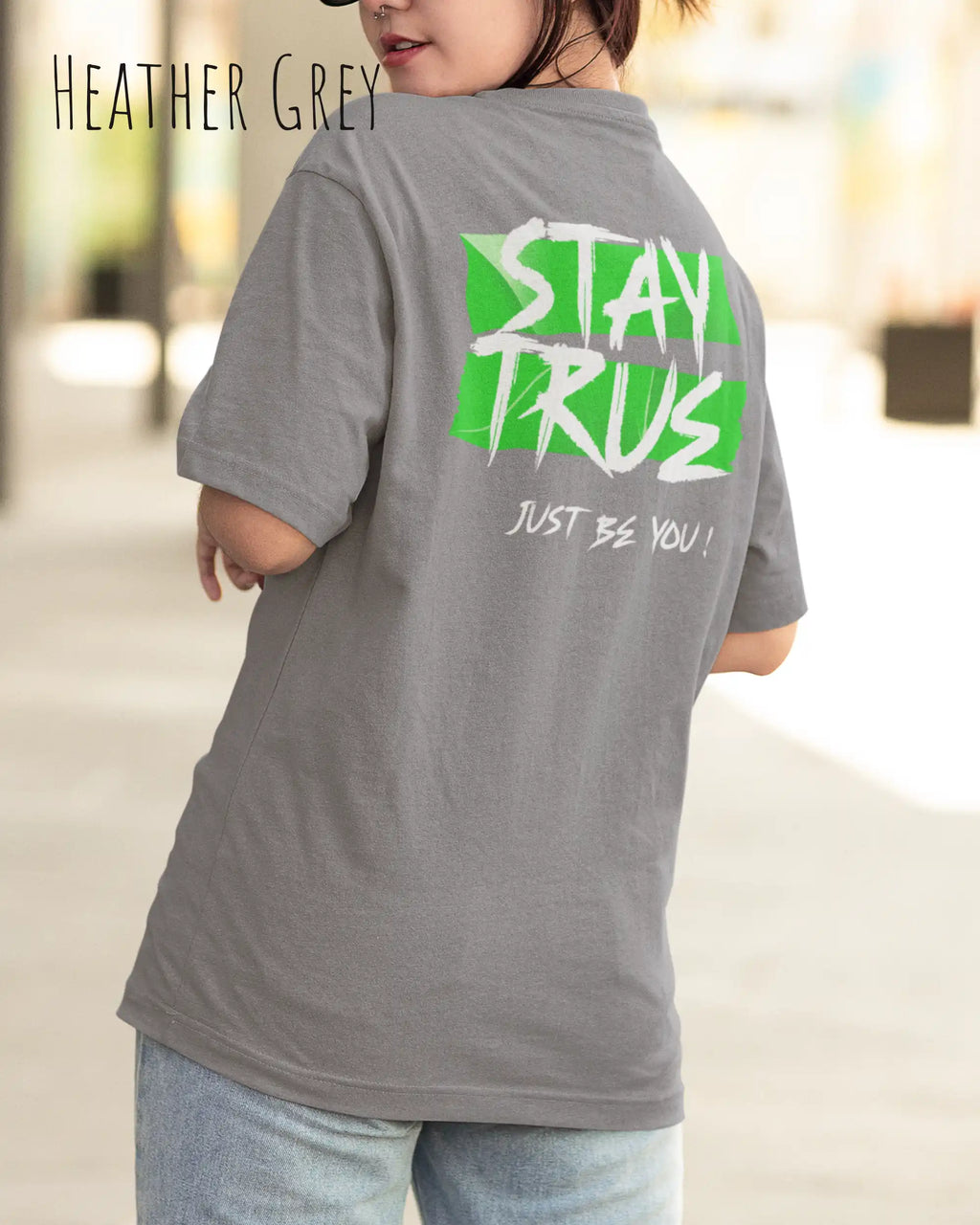 auf diesem bild trägt eine frau ein oversized heavyweight design-t-shirt in der farbe heather grey mit dem statement-motiv stay true auf dem rücken