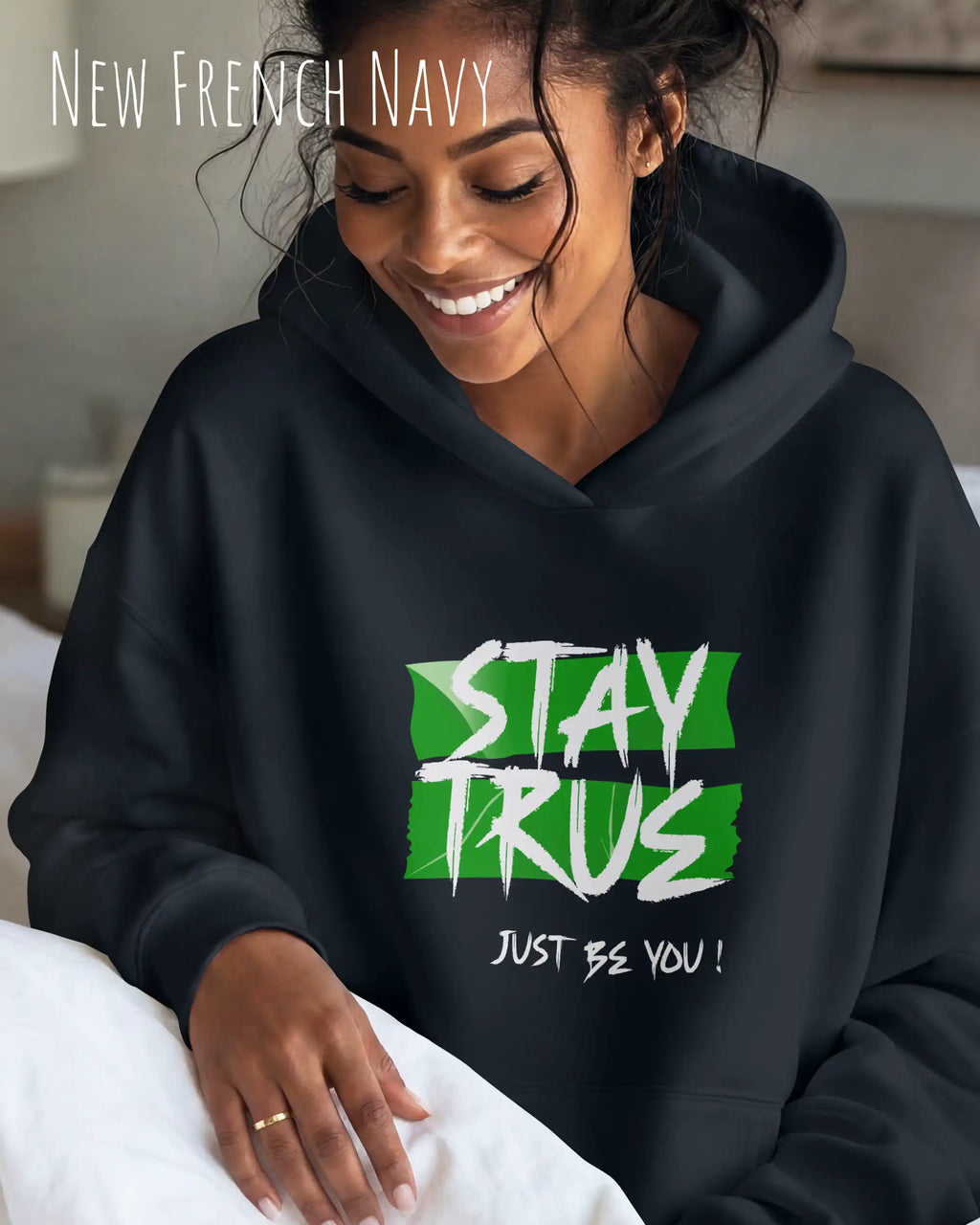 das bild zeigt eine lächelnde frau, die einen Oversized Design-Hoodie in der farbe new french navy mit dem ausdrucksstarken motiv "stay true ... just be you" trägt.
