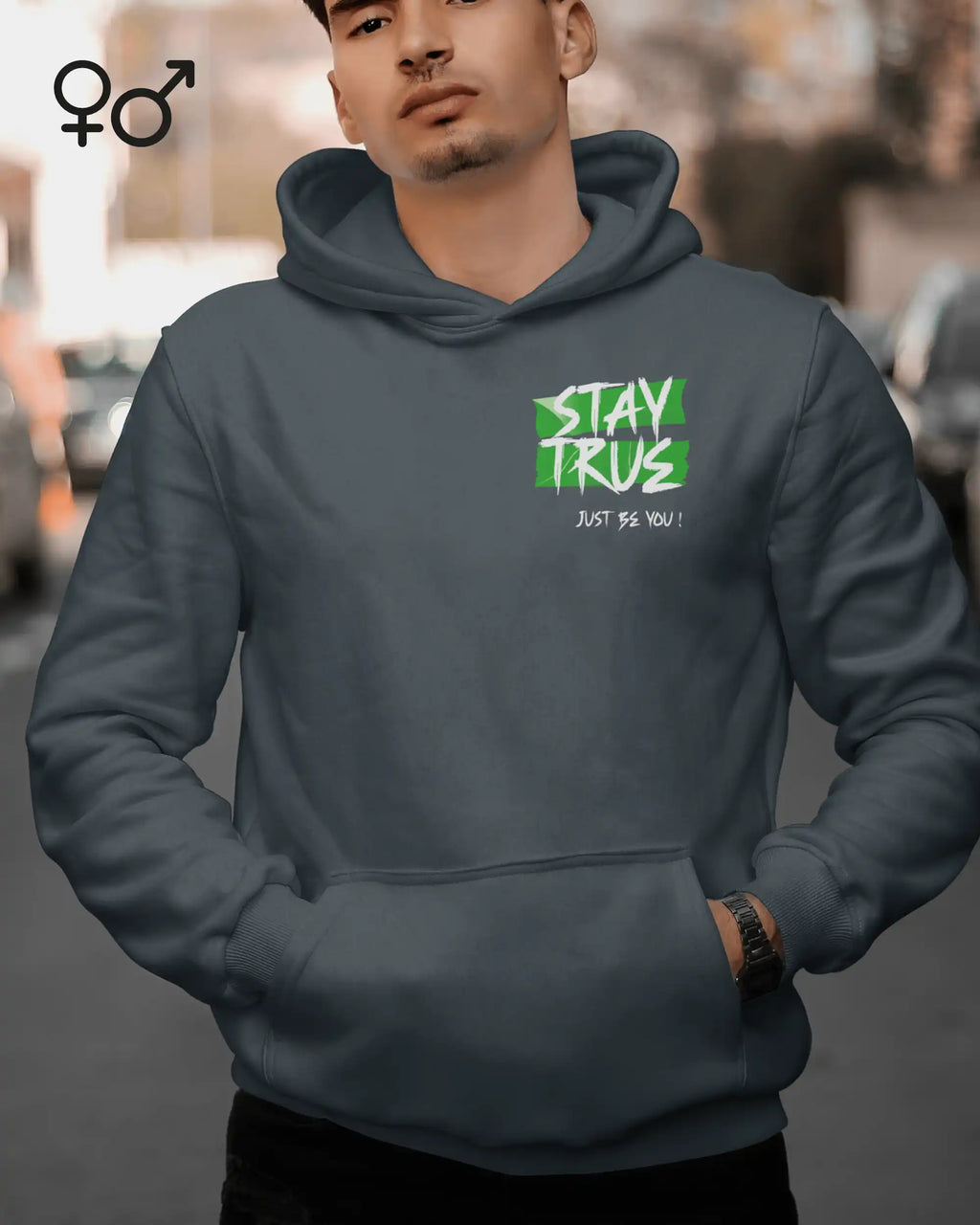 das bild zeigt einen mann, der einen Oversized Design-Hoodie mit dem ausdrucksstarken motiv "stay true ... just be you" oben links trägt.