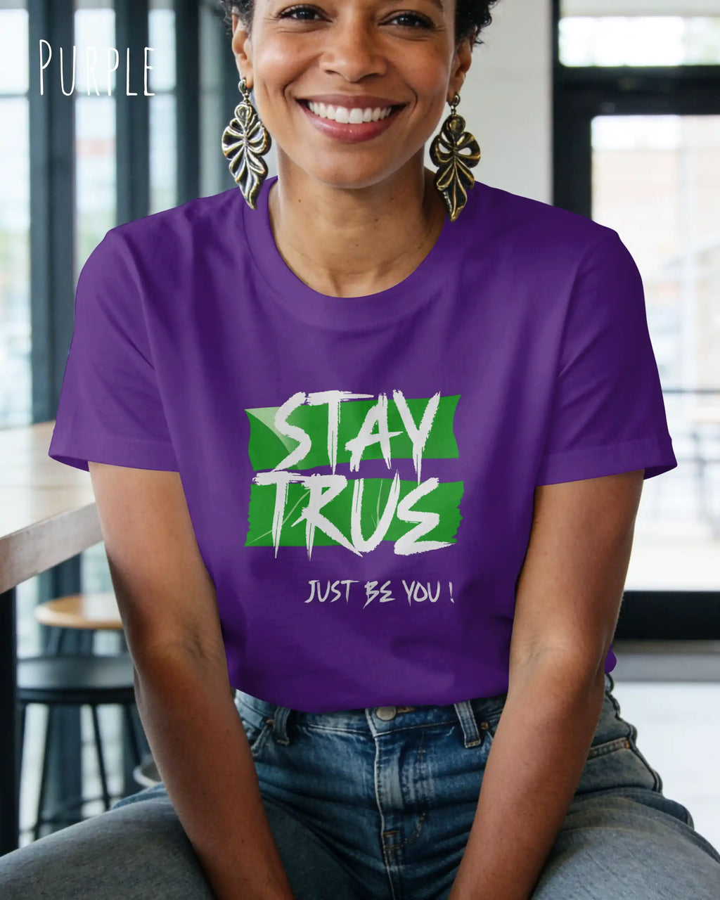 eine frau trägt ein design t-shirt mit figurbetontem Schnitt in der farbe purple und mit dem motiv stay true vorne auf der brust.
