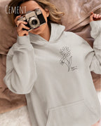 Frau trägt einen heavyweight oversized hoodie in der farbe cement mit dem minimaoistischen Design keep it simple links vorne.