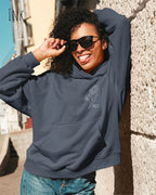 Frau trägt einen heavyweight oversized hoodie in der farbe ink mit dem minimaoistischen Design keep it simple.