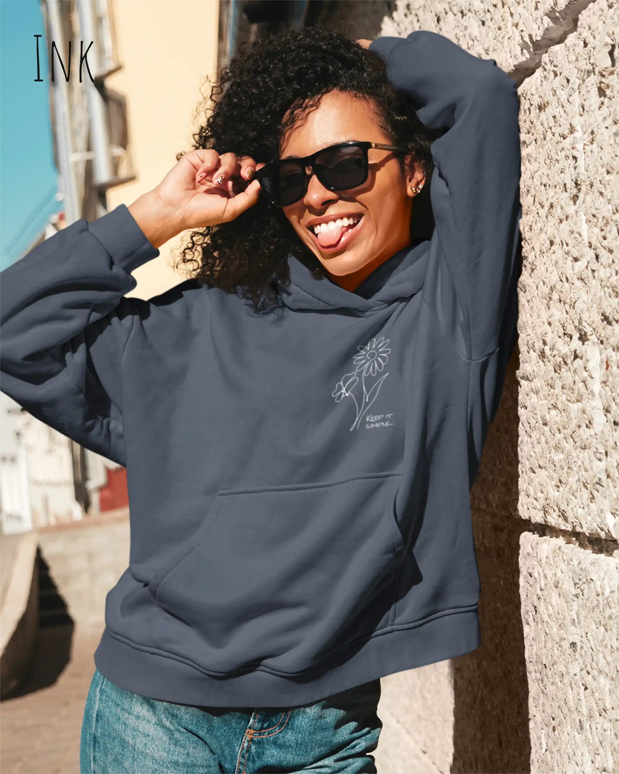 Frau trägt einen heavyweight oversized hoodie in der farbe ink mit dem minimaoistischen Design keep it simple.