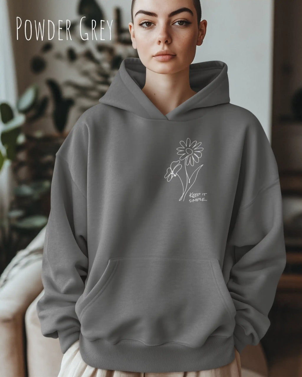 Frau trägt einen heavyweight oversized hoodie in der farbe powder grey mit dem minimaoistischen Design keep it simple.