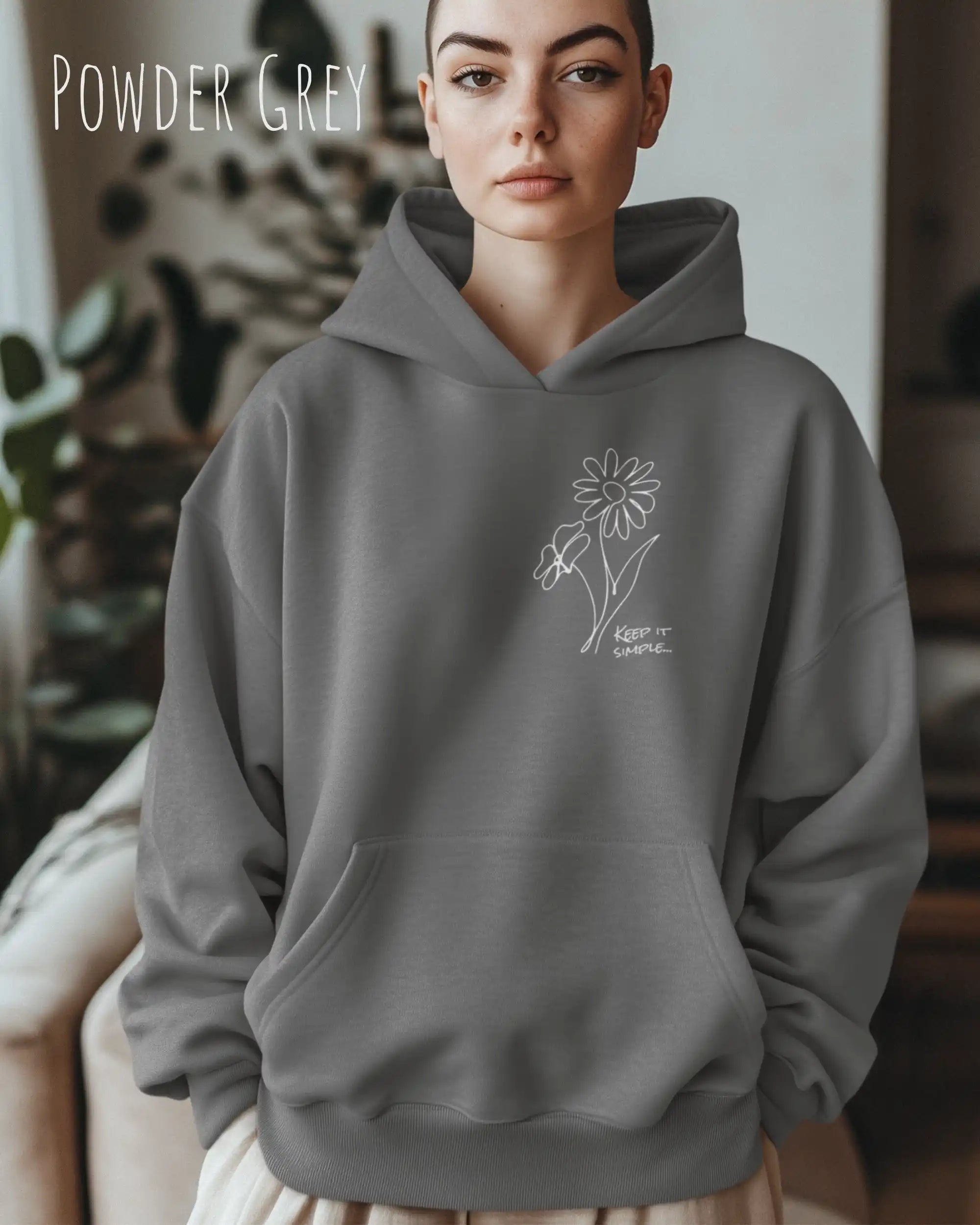 Frau trägt einen heavyweight oversized hoodie in der farbe powder grey mit dem minimaoistischen Design keep it simple.