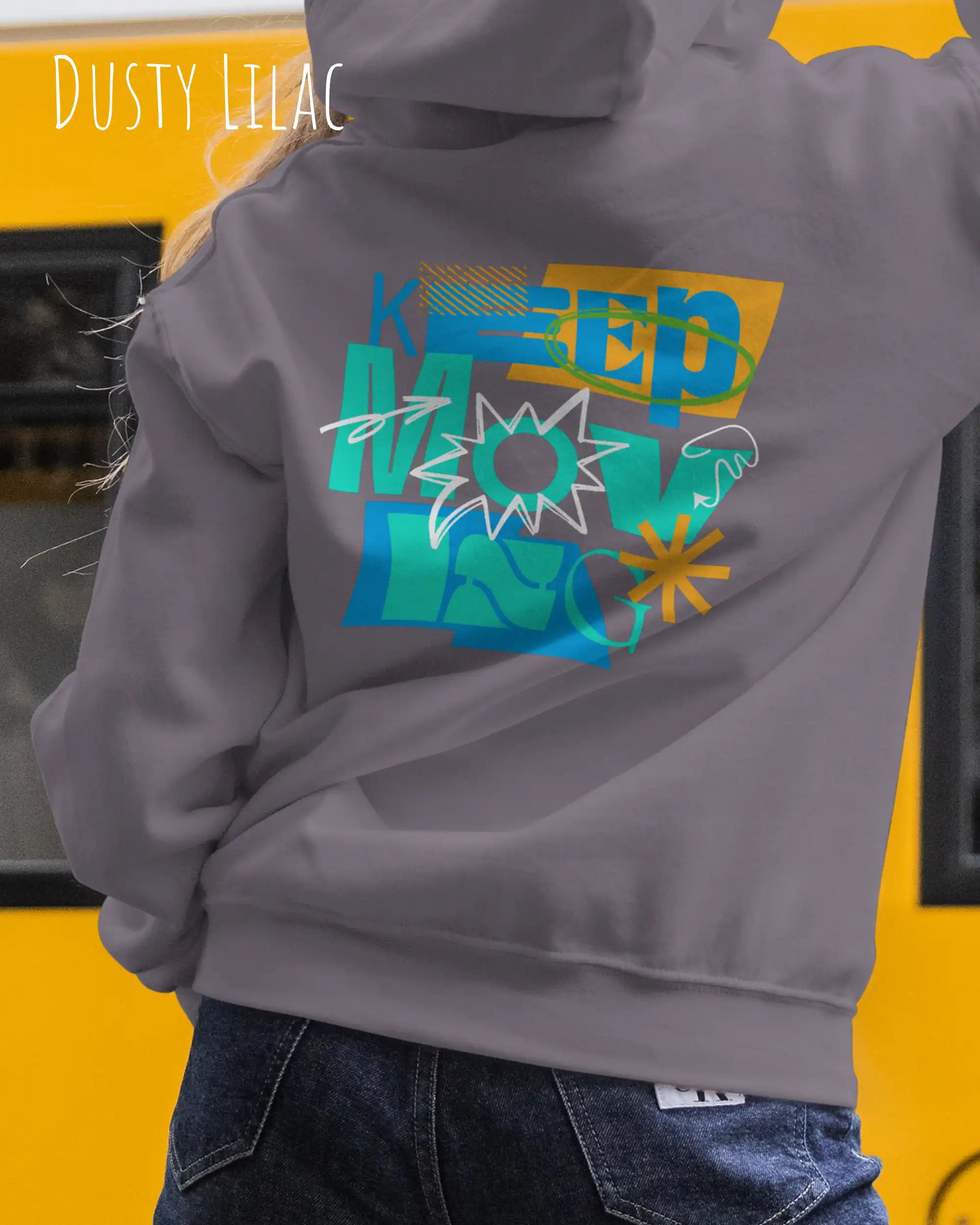 eine frau trägt einen Oversized Design-Hoodie in dusty lilac mit der motivierenden grafik "keep moving" auf dem rücken.