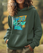 eine frau trägt einen Oversized Design-Hoodie in moss green mit der motivierenden grafik "keep moving".