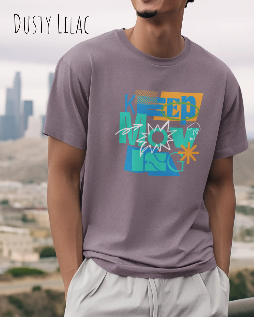 mann trägt ein design-t-shirt in der farbe dusty lilac  mit dem mit dem Motiv keep moving.