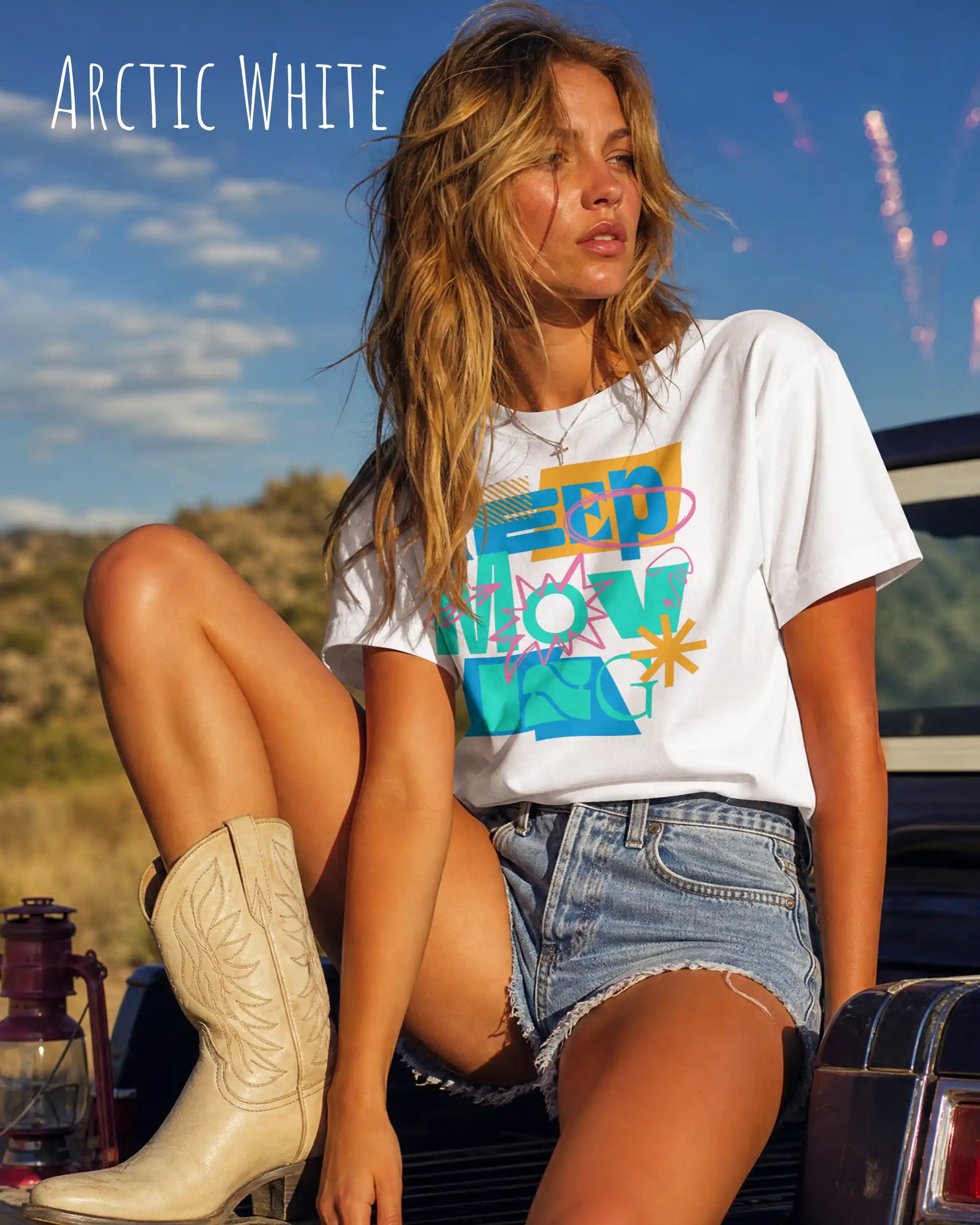 blonde frau trägt ein oversized heavyweight design-t-shirt in der Farbe arctic white mit dem motivierenden Schriftzug „KEEP MOVING“.