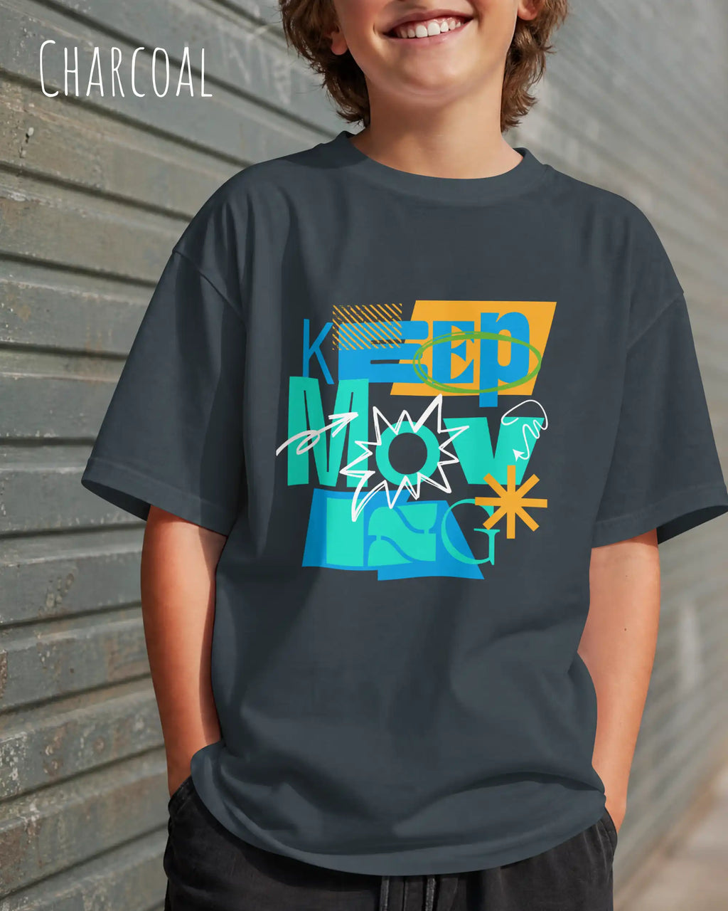 junger mann trägt ein oversized heavyweight design-t-shirt in der Farbe charcoal mit dem motivierenden Schriftzug „KEEP MOVING“.
