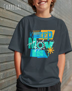 junger mann trägt ein oversized heavyweight design-t-shirt in der Farbe charcoal mit dem motivierenden Schriftzug „KEEP MOVING“.