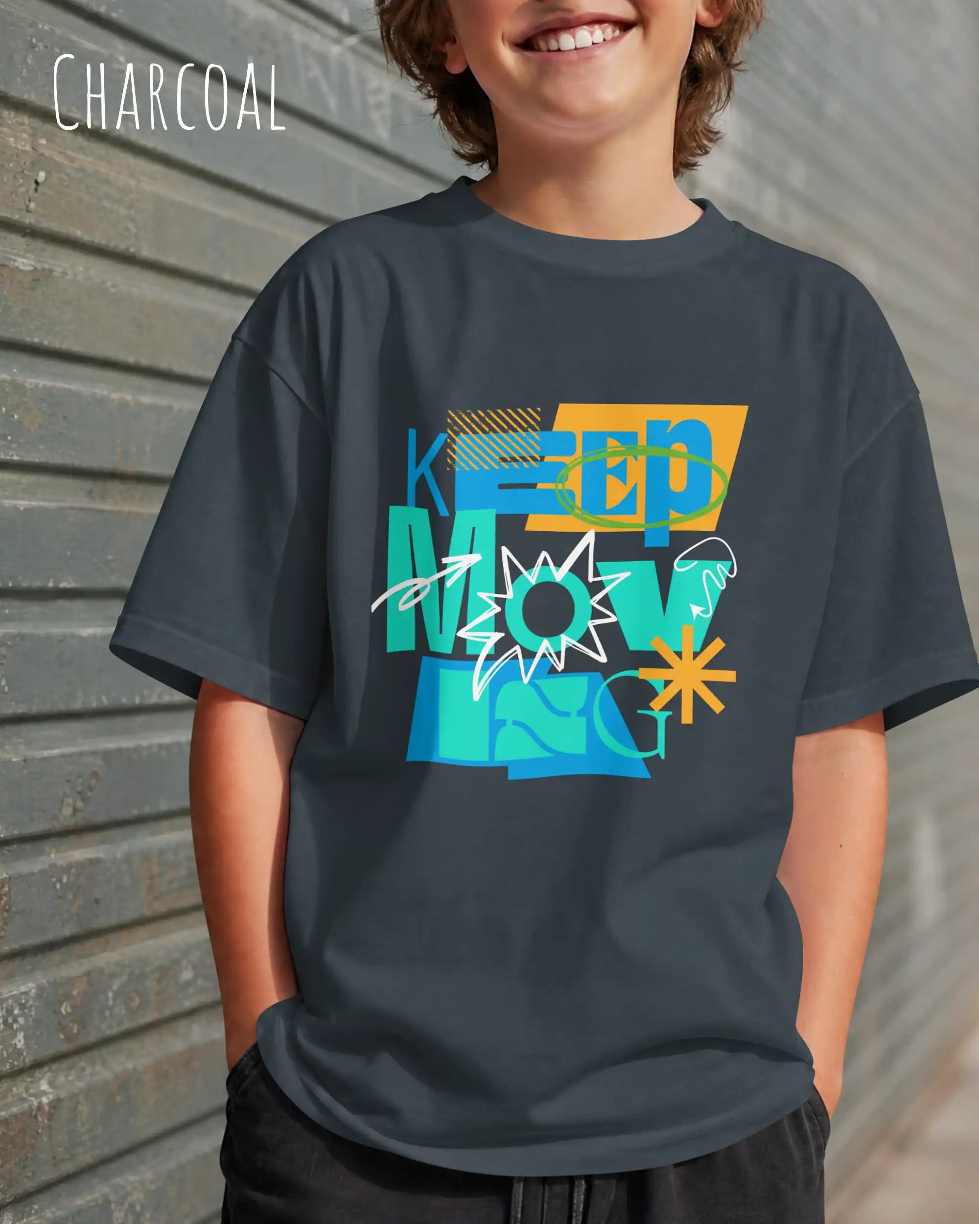 junger mann trägt ein oversized heavyweight design-t-shirt in der Farbe charcoal mit dem motivierenden Schriftzug „KEEP MOVING“.
