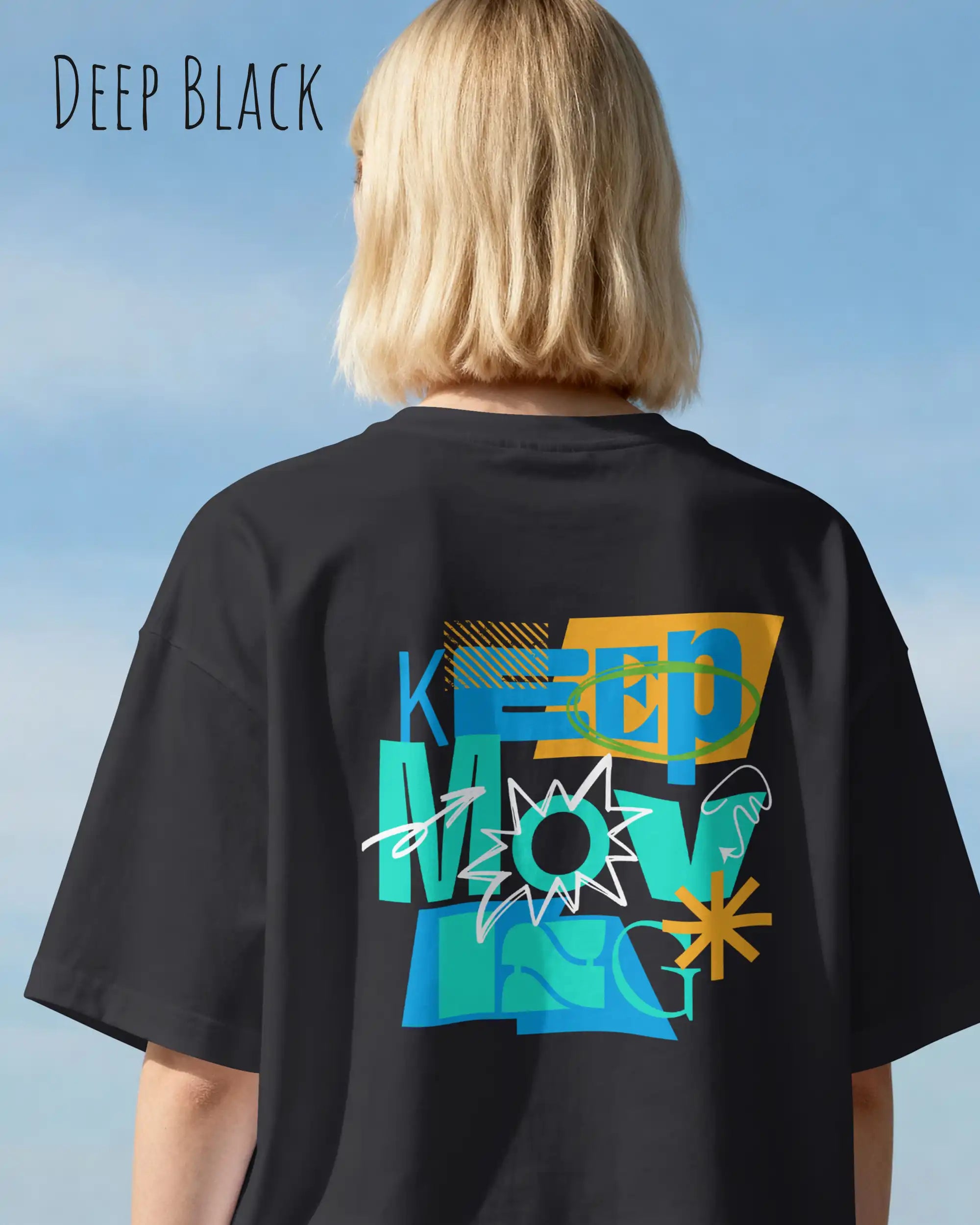 blonde frau trägt ein oversized heavyweight design-t-shirt in der Farbe deep black mit dem motivierenden Schriftzug „KEEP MOVING“ als backprint.