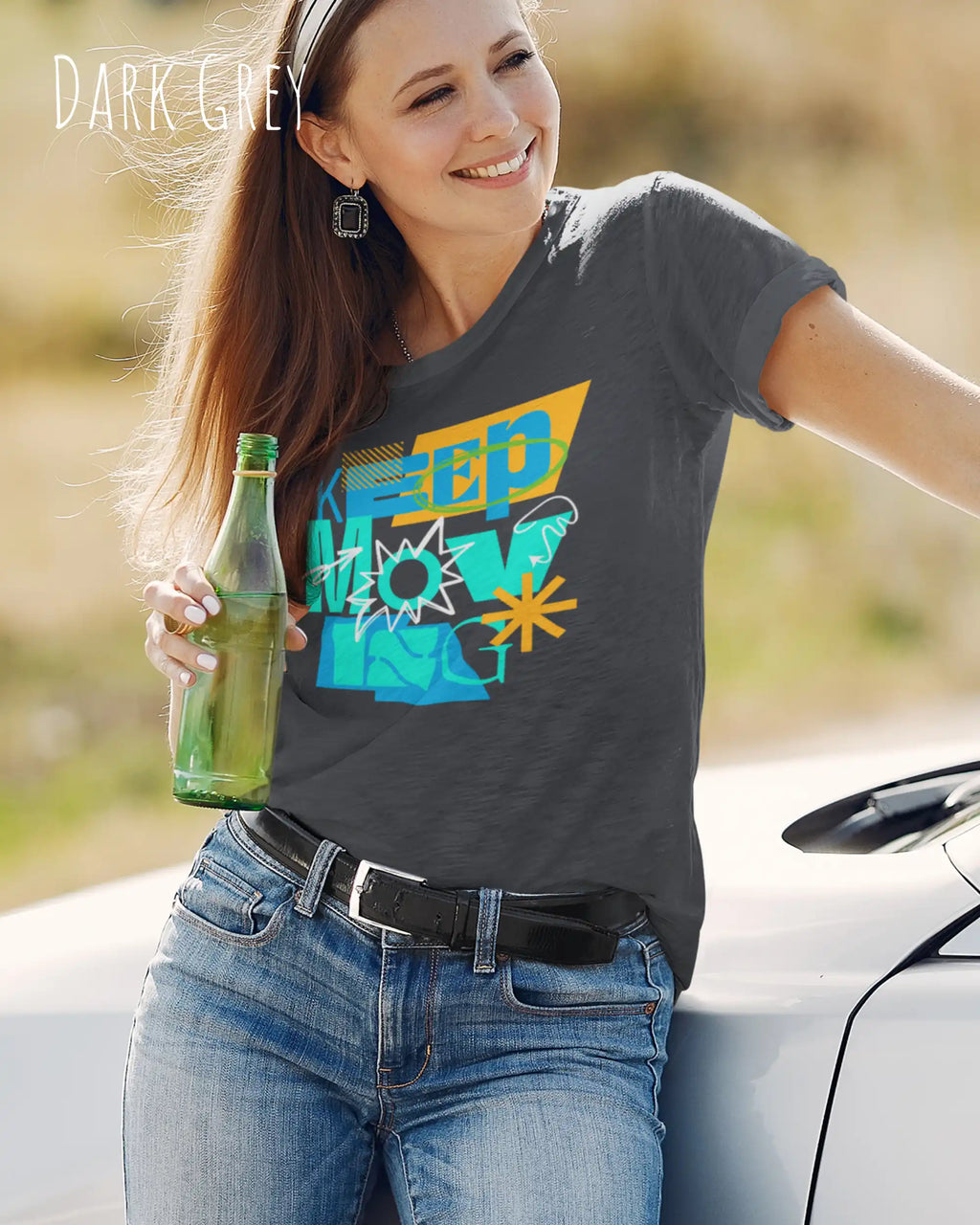 das bild zeigt eine lächelnde  frau, die ein damen design-t-shirt in der farbe dark grey mit dem Motiv "keep moving" trägt,