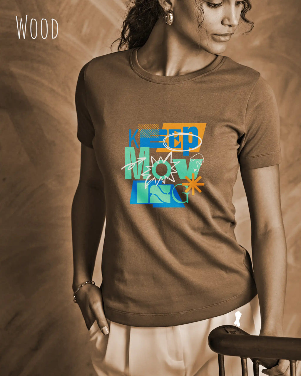 Dieses Bild zeigt eine frau, die ein feminines design-T-Shirt in der farbe wood und mit der motivierenden grafik "keep moving" trägt.