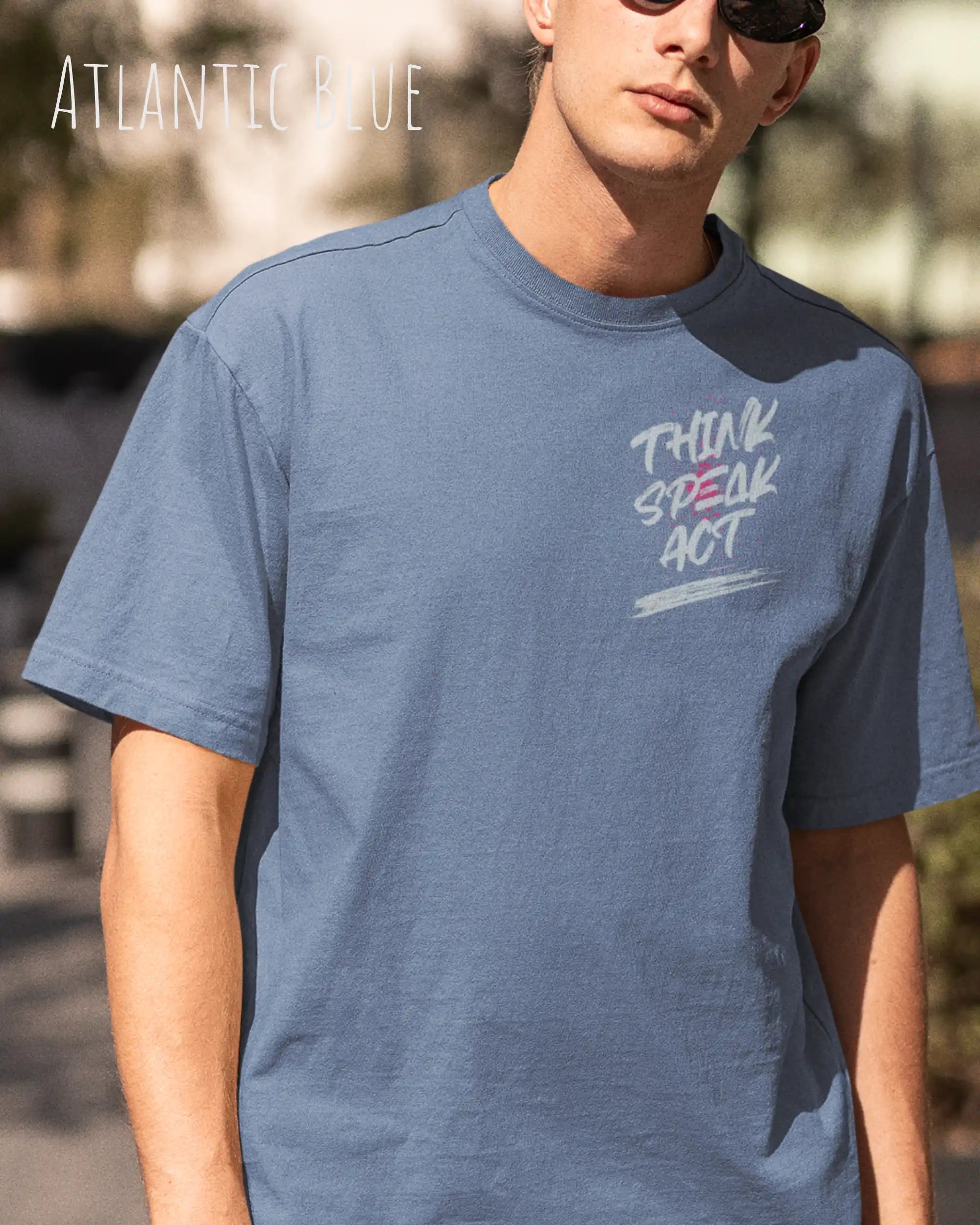 Mann trägt das Heavyweight Oversized T-Shirt AWDis 240 T in der Farbe atlantic bleu mit dem Design -THINK SPEAK ACT oben links.