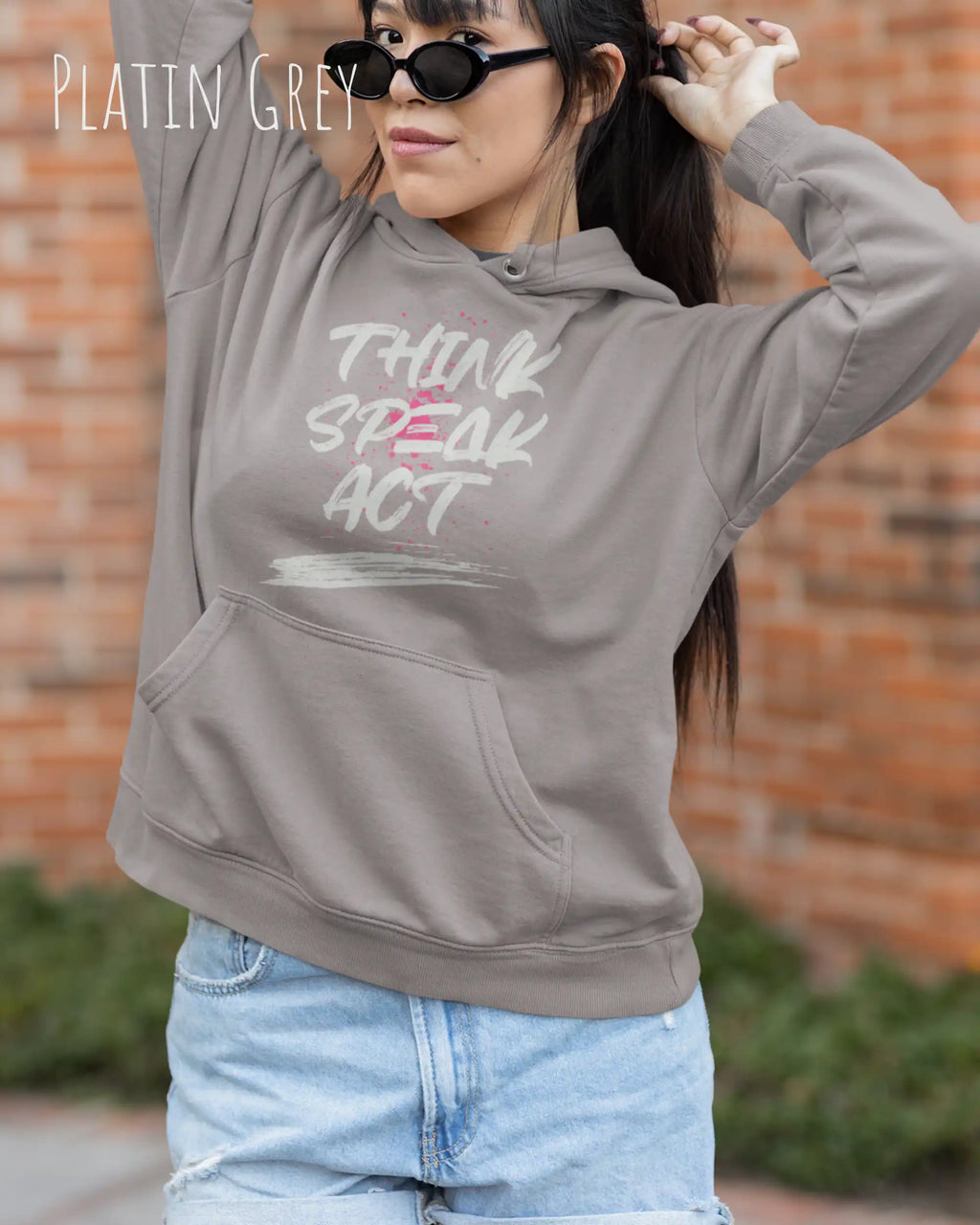 Eine Frau trägt den unisex basic hoodie JH001 von awdis in der Farbe Platin grey mit dem STATEMENT Design THINK SPEAK ACT