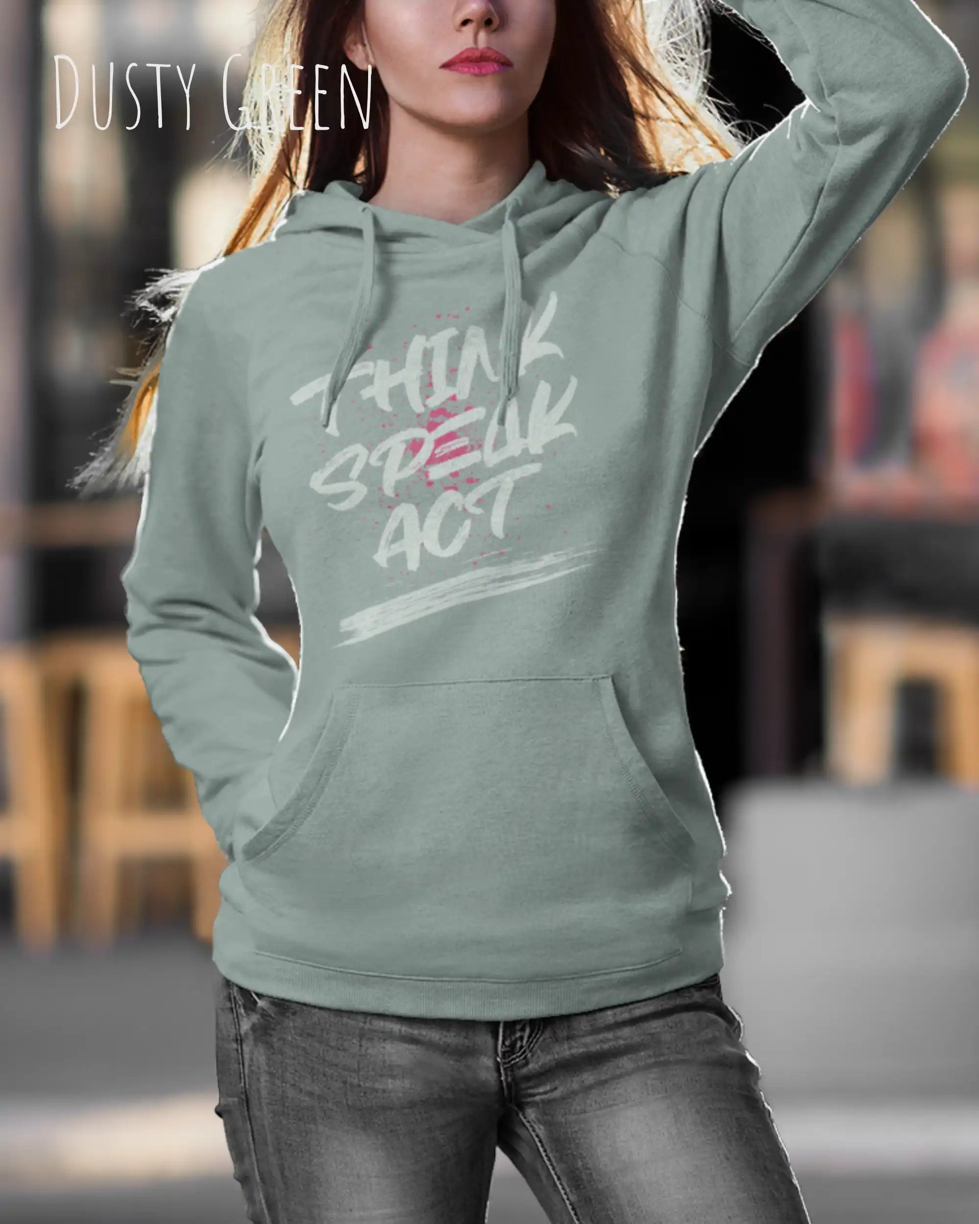 Eine Frau trägt den damen design hoodie JH001F von awdis in der Farbe dusty green mit dem STATEMENT Design THINK SPEAK ACT