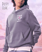 Junge frau trägt streetwear hoodie im oversize fit in farbe dusty lilac mit think speak act motiv oben links auf der Brust