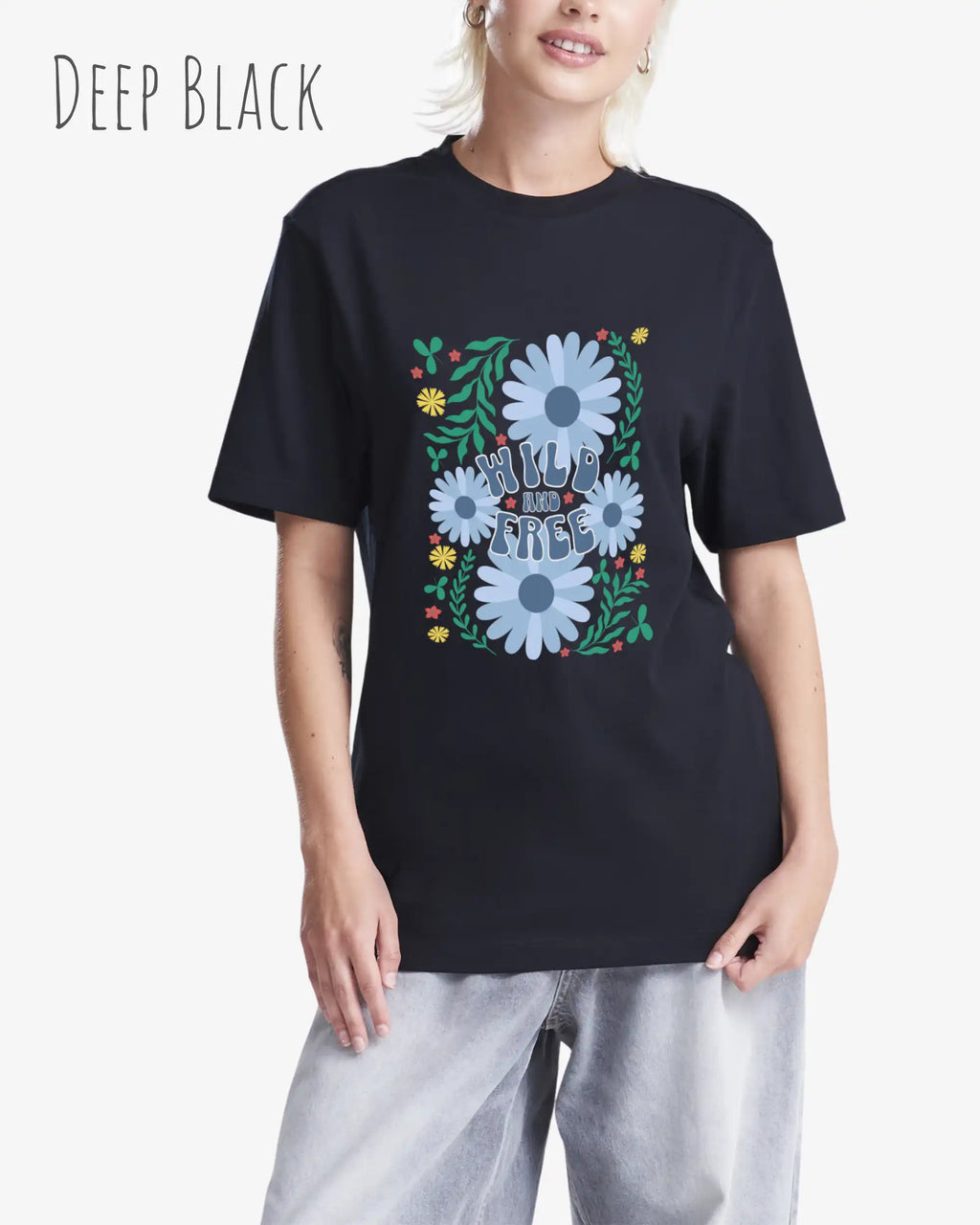 Das Bild zeigt eine Frau, die ein Design-T-Shirt in der farbe deep black  aus atmungsaktiver Baumwolle  mit dem statement WILD AND FREE trägt.