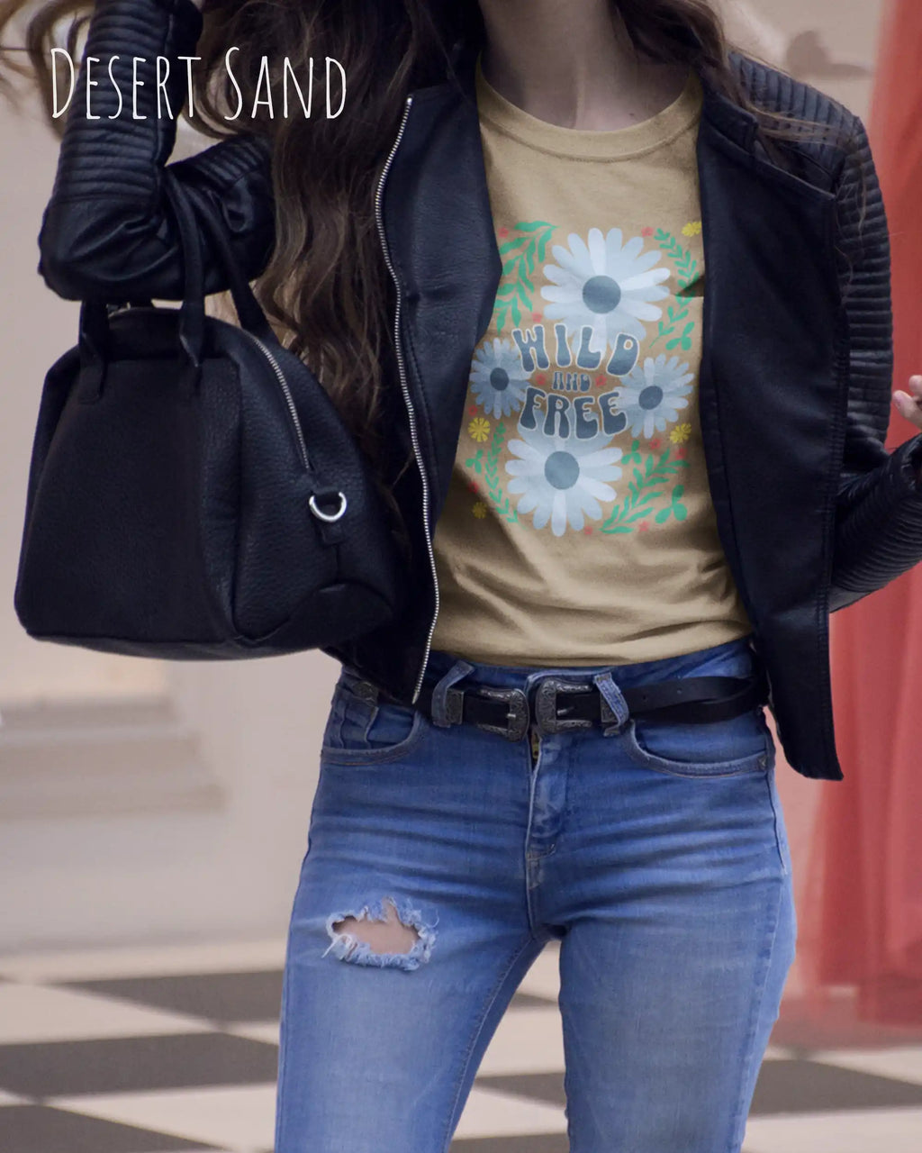 Das Bild zeigt eine Frau, die ein Design-T-Shirt in der farbe desert sand  aus atmungsaktiver Baumwolle  mit dem statement WILD AND FREE trägt.