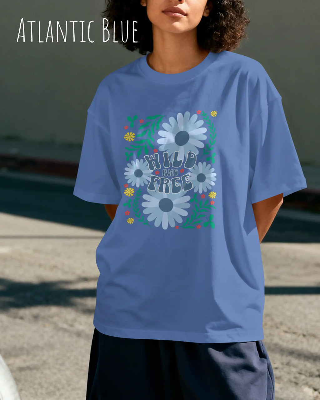 junge  frau trägt ein oversized heavyweight design-t-shirt in der farbe atlantic blue und mit dem motiv wild and free.