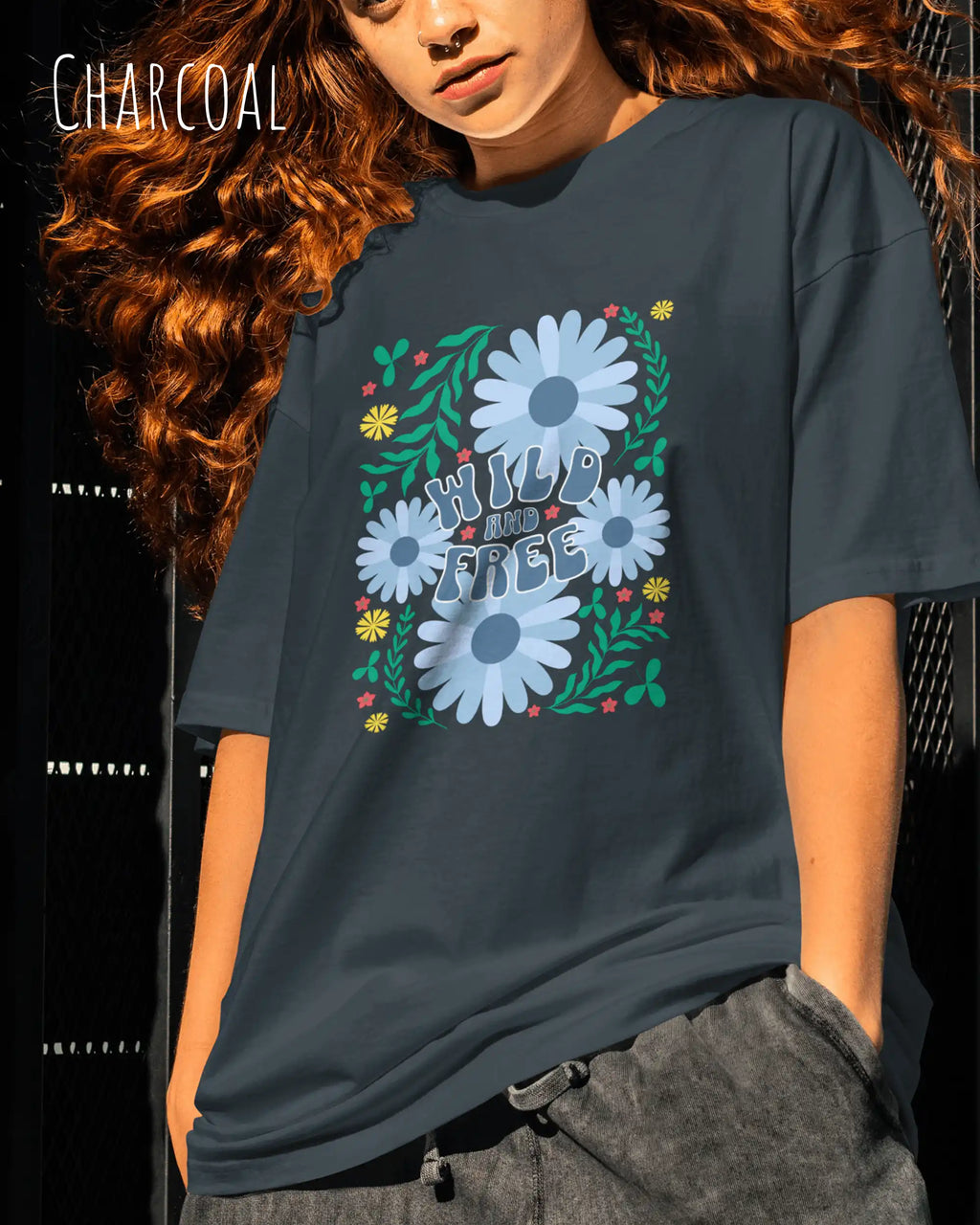 junge frau trägt ein oversized heavyweight design-t-shirt in der farbe charcoal und mit dem motiv wild and free.