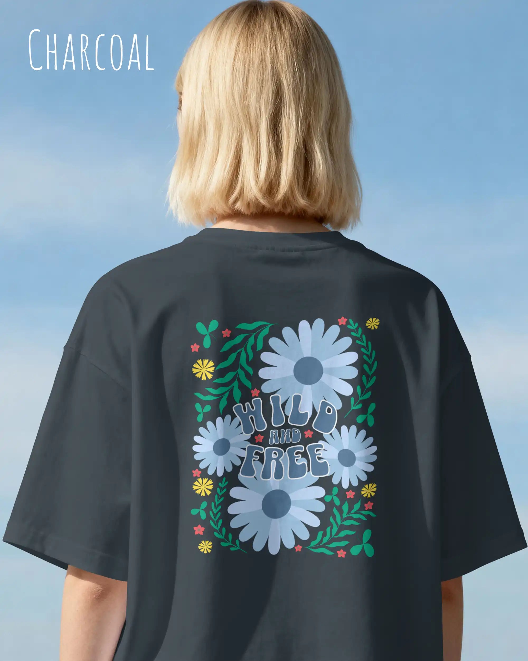blonde frau trägt ein oversized heavyweight design-t-shirt in der farbe charcoal und mit dem backprint wild and free.