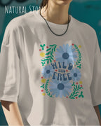 blonde frau trägt ein oversized heavyweight design-t-shirt in der farbe natural stone und mit dem motiv wild and free.