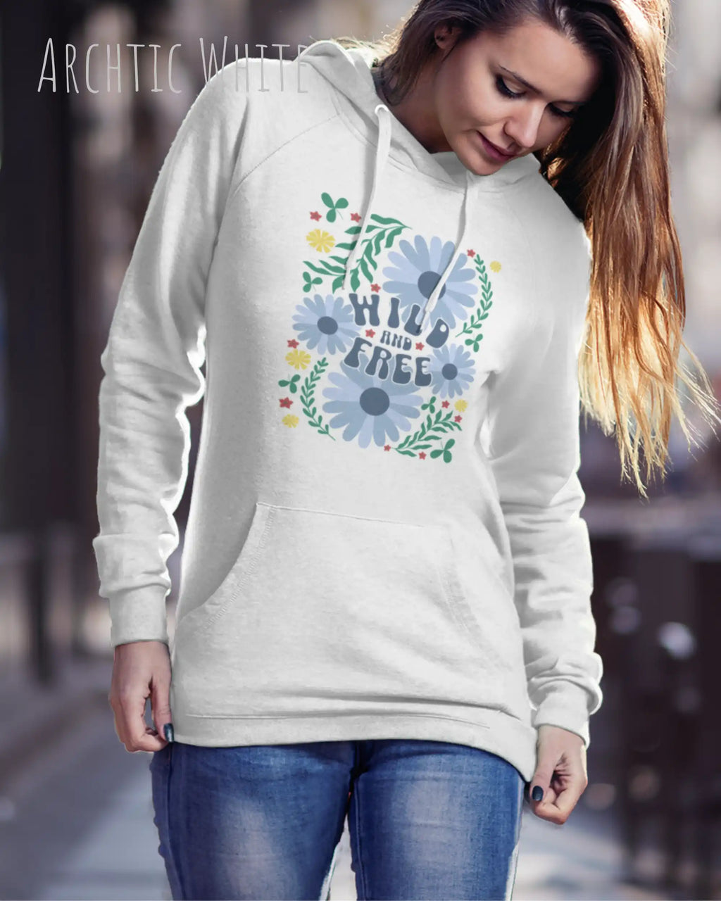 JUNGE FRAU TRÄGT einen damen design hoodie in der Farbe ARCTIC WHITE mit dem STATEMENT  WILD AND FREE.