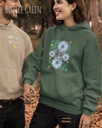 EINE FRAU TRÄGT einen damen design hoodie in der Farbe BOTTLE GREEN mit dem STATEMENT  WILD AND FREE.