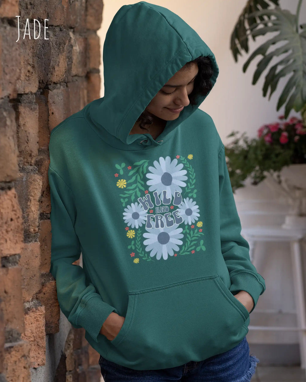 FRAU TRÄGT einen damen design hoodie in der Farbe JADE mit dem STATEMENT  WILD AND FREE.
