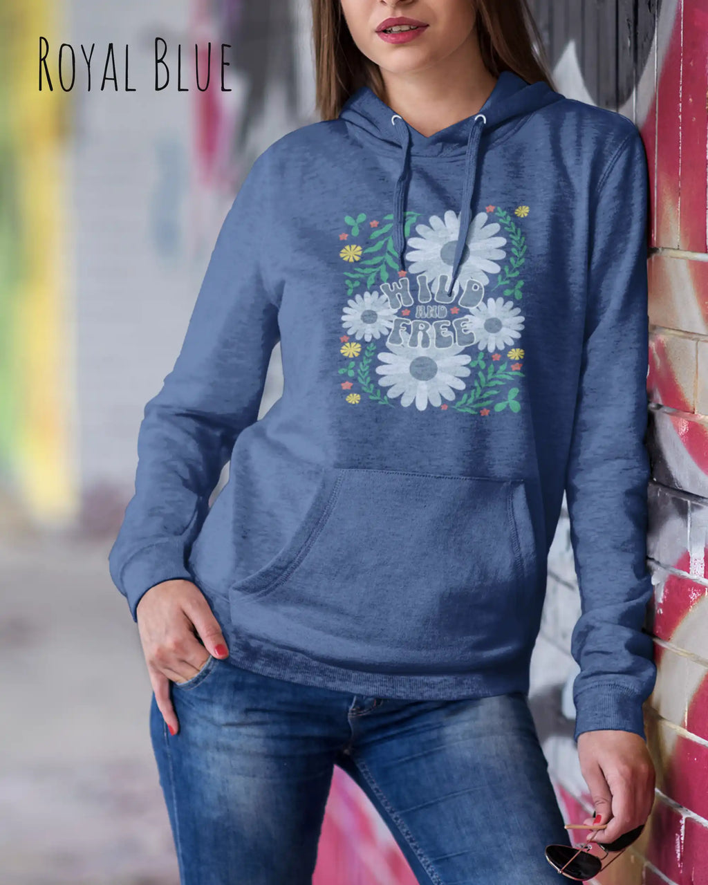 JUNGE FRAU TRÄGT einen damen design hoodie in der Farbe ROYAL BLUE mit dem STATEMENT  WILD AND FREE.