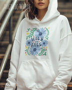 Eine Frau trägt einen Oversized Design-Hoodie in arctoc white mit dem Statement wild and free,